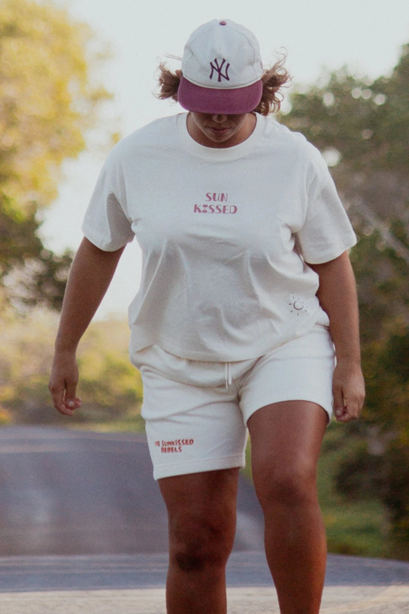 Locker geschnittene Sweat Shorts in Cream beim Gehen auf einer Straße im natürlichen Licht