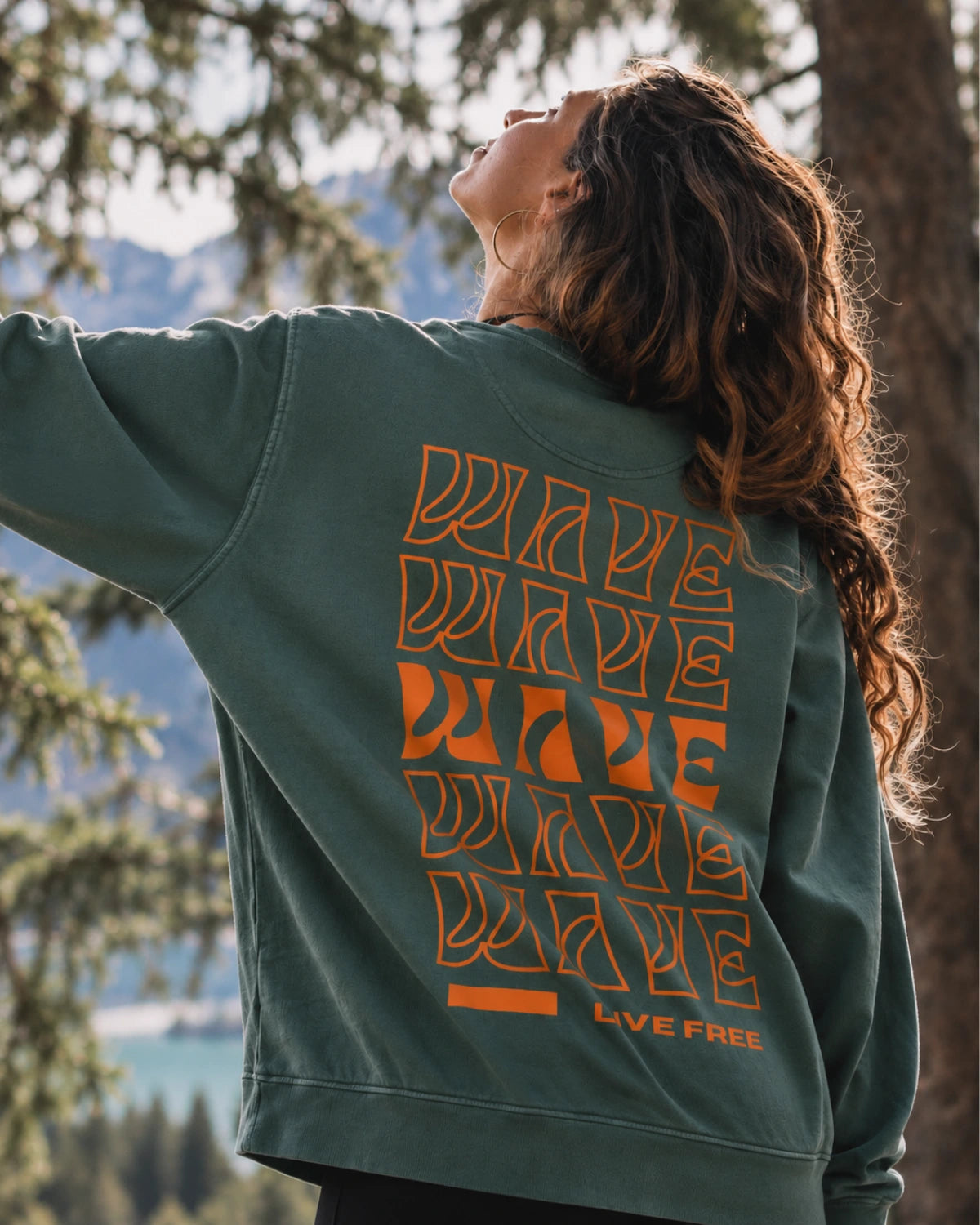 Detailansicht des orangenen Live Free Rückenprints auf dem Palm Green Vintage Sweater von The Sunkissed Rebels