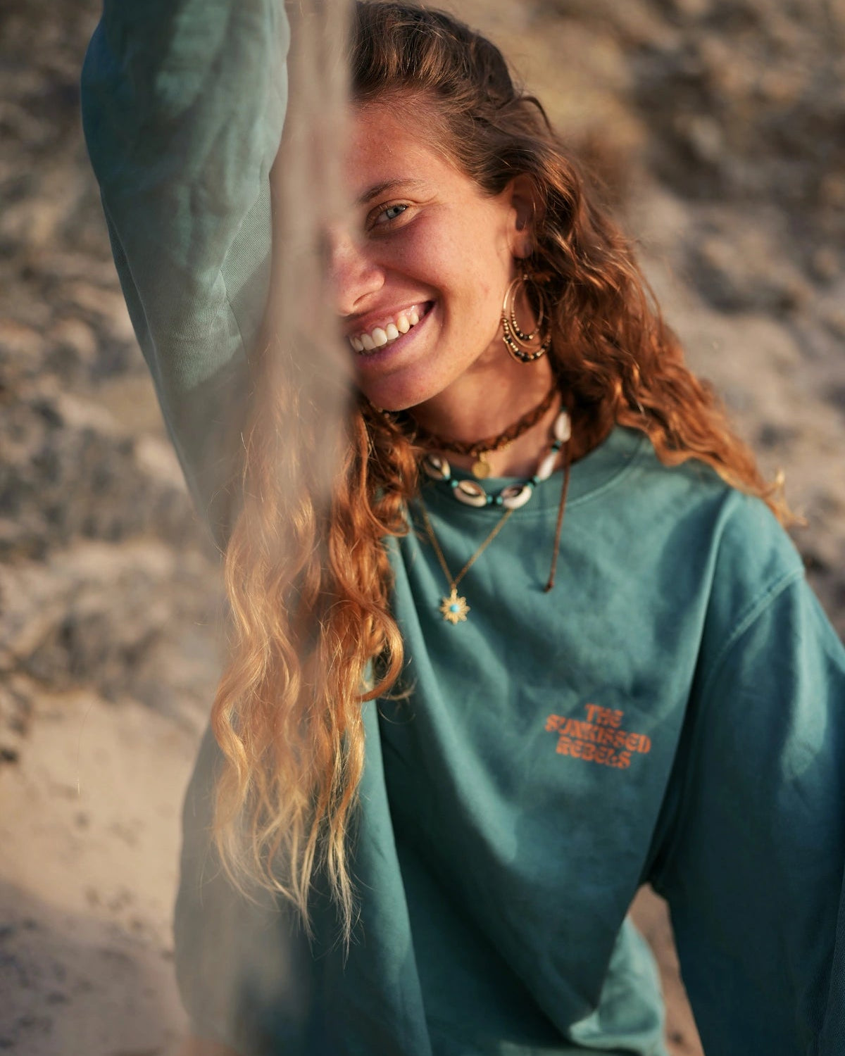 Frau mit Muschelkette lächelt in Palm Green Live Free Sweater