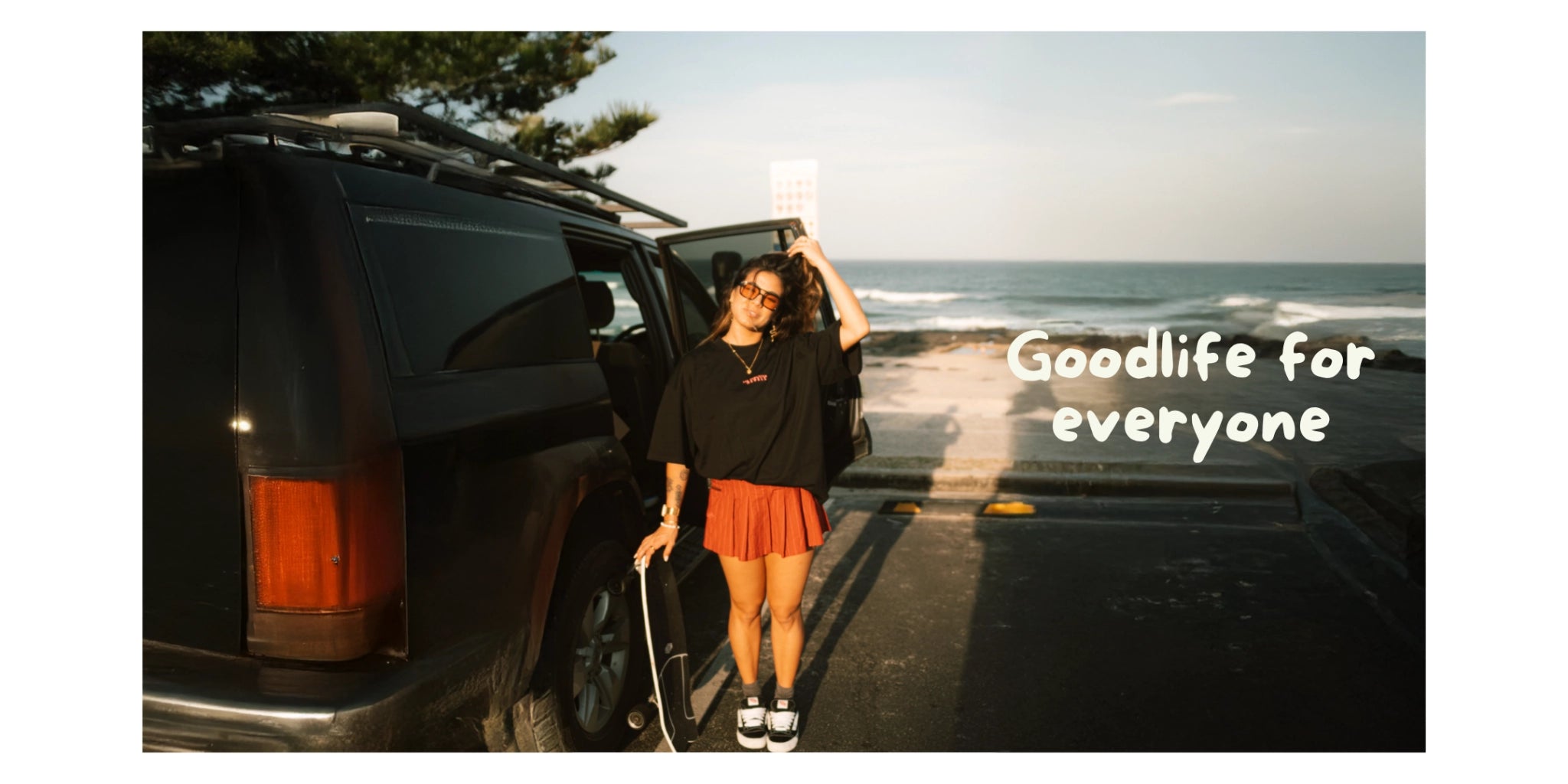 Frau steht vor Auto und trägt schwarzes Oversized T-Shirt und Mini Rock