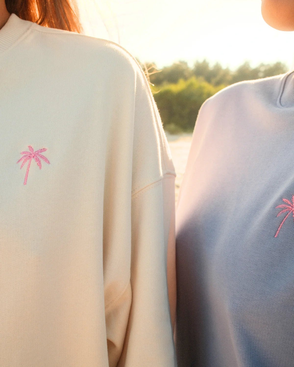 Nahaufnahme der rosa Palmen-Stickerei auf dem hellen Palm Tree Oversized Sweater in Cream von The Sunkissed Rebels.