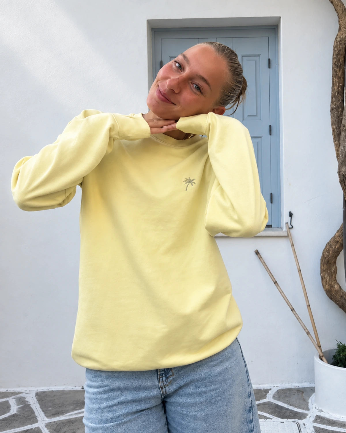 Frau trägt den Palm Tree Sweater in Butter von The Sunkissed Rebels im lässigen Oversized Fit