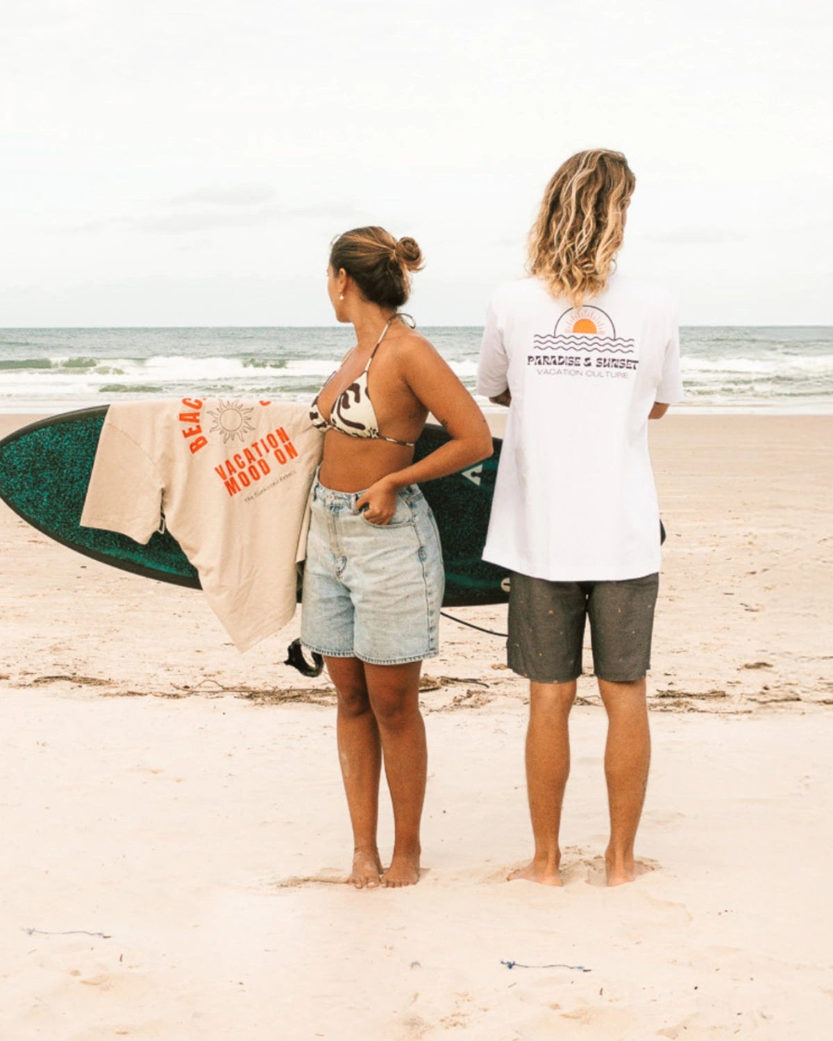 Surferin und Surfer am Strand Rückansicht.