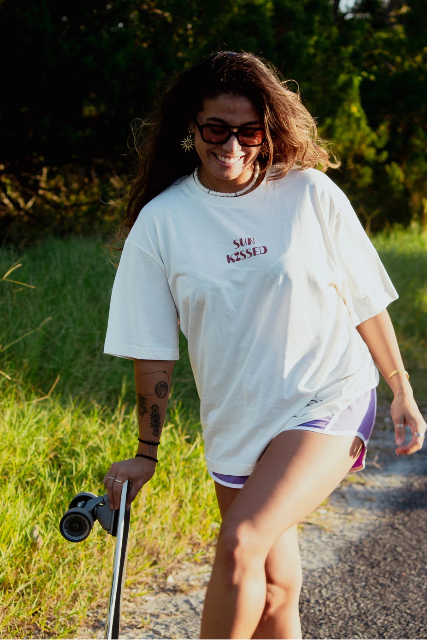 Frau trägt Sunkissed Light T Shirt Natural Raw kombiniert mit Shorts im Streetstyle