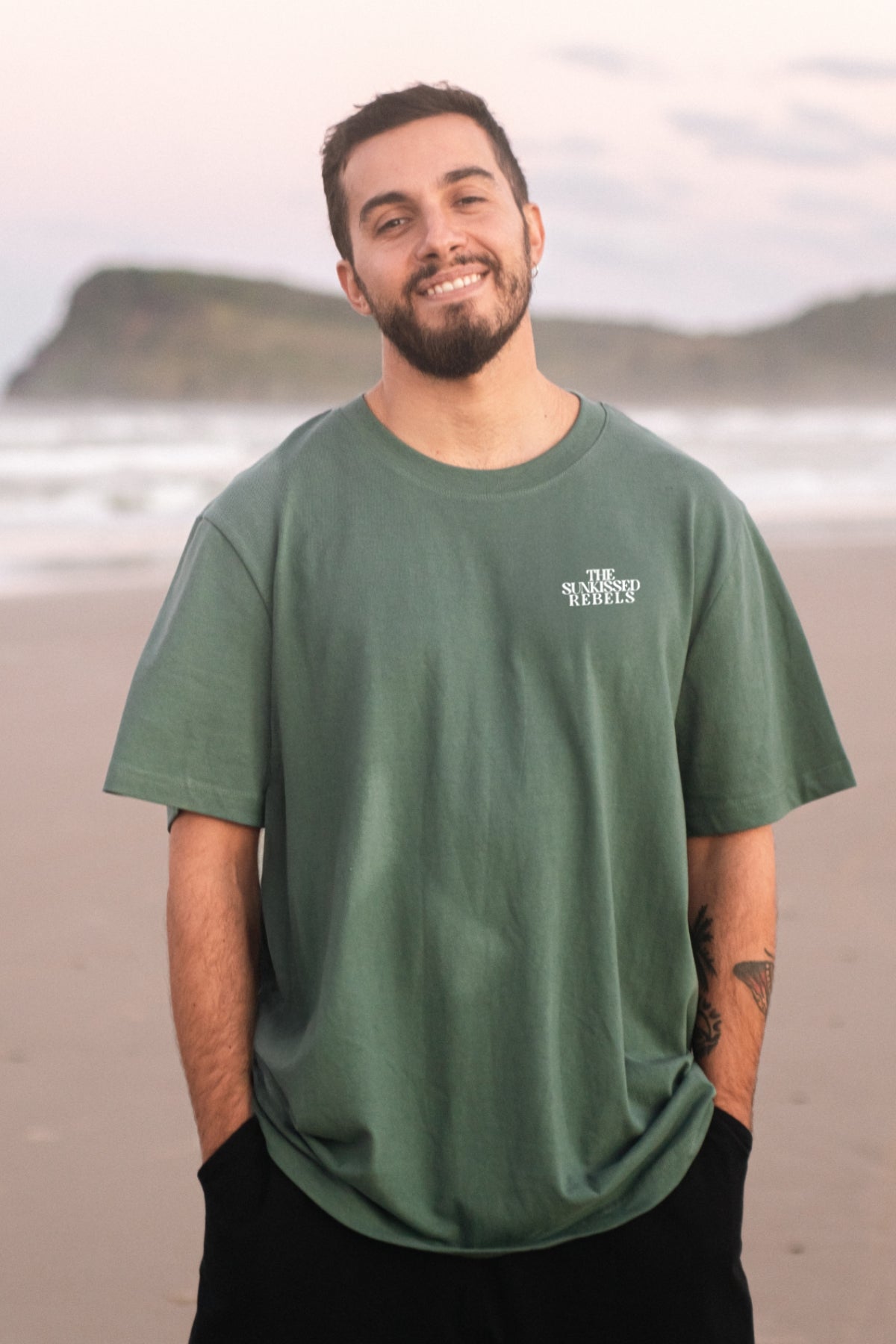 Mann trägt am Strand das Oversized Vacation Mood On T-Shirt von The Sunkissed Rebels