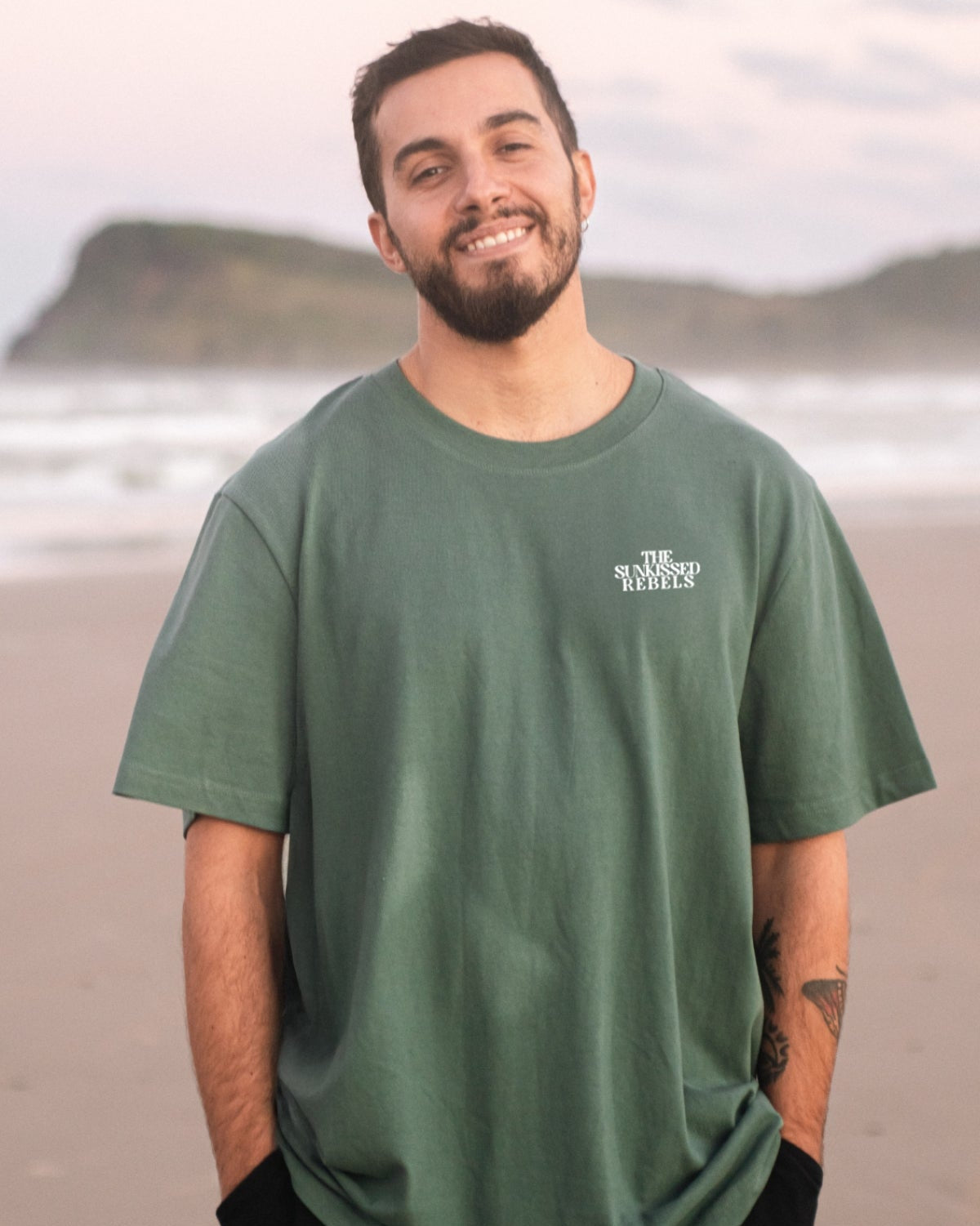 Mann trägt am Strand das Oversized Vacation Mood On T-Shirt von The Sunkissed Rebels