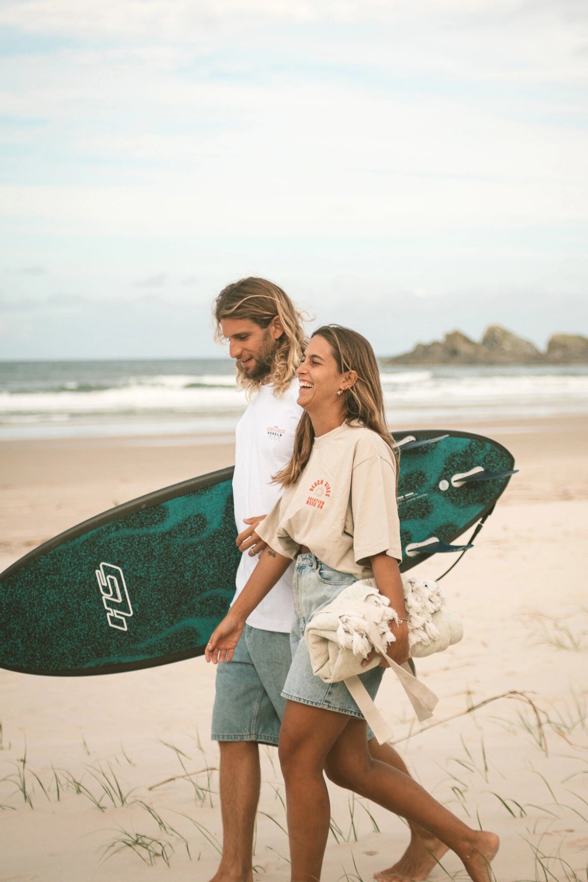 Strandaufnahme: Frau trägt das Vacation Mood T-Shirt in Sand – sommerlicher Surferstyle
