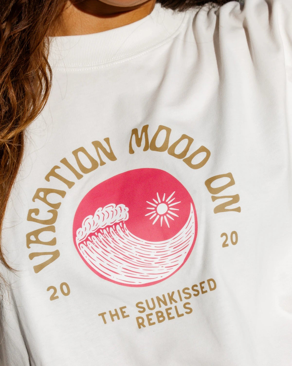 Detailaufnahme des pinken Wellenprints mit Sonne auf dem "Vacation Mood On" Shirt
