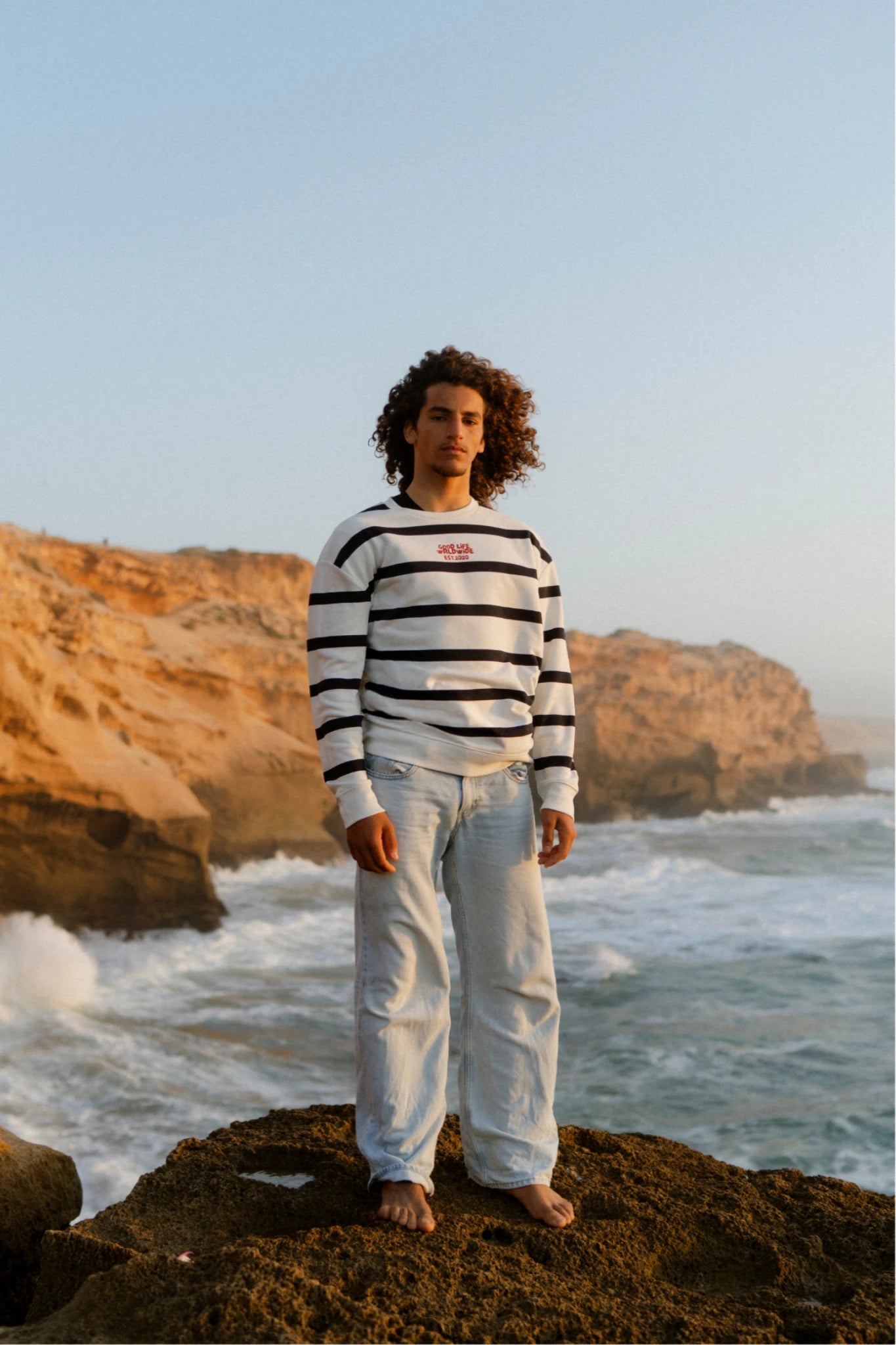 Herren trägt Dockside Rebel Sweater Vintage Cream am Meer frontal
