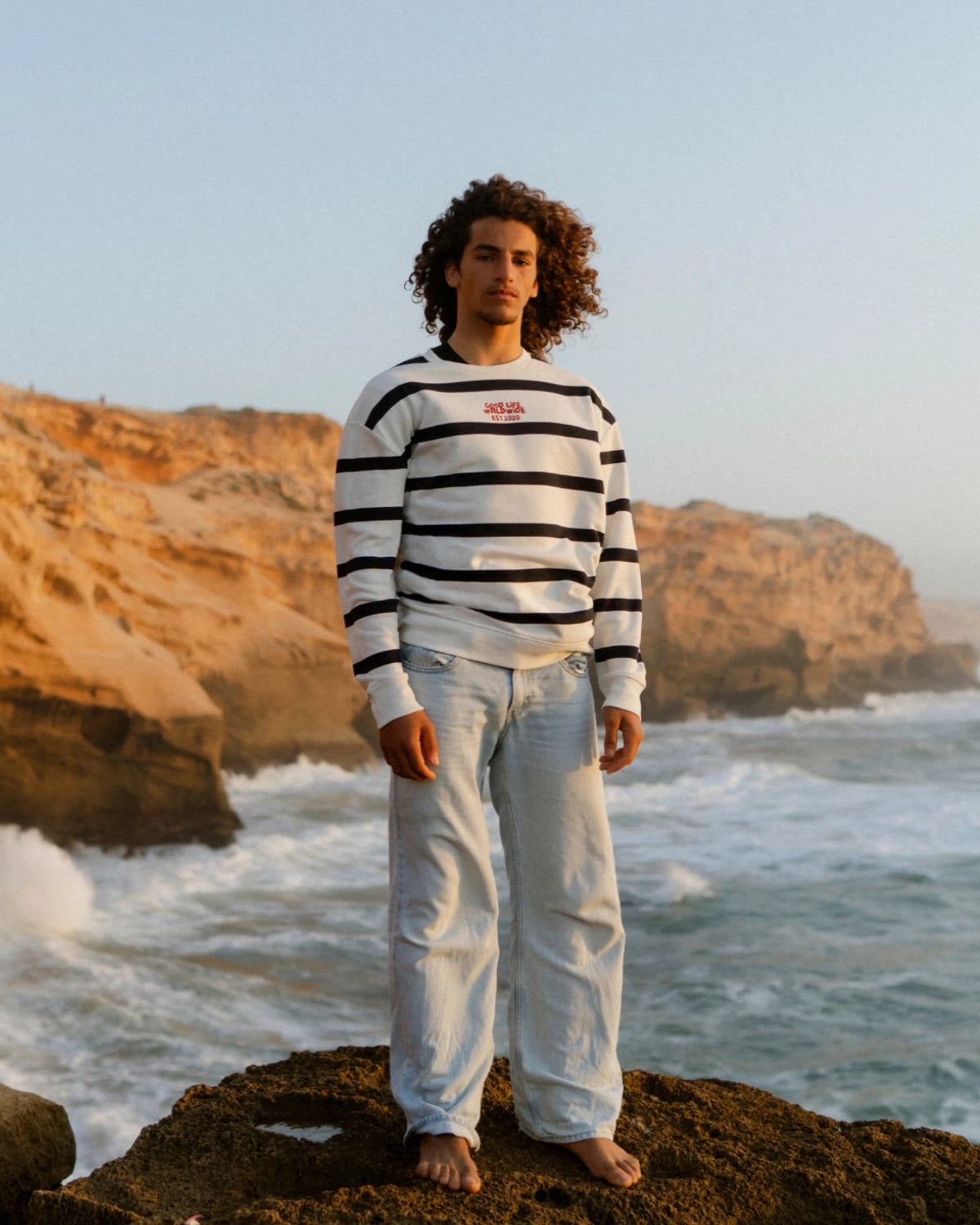 Herren trägt Dockside Rebel Sweater Vintage Cream am Meer frontal
