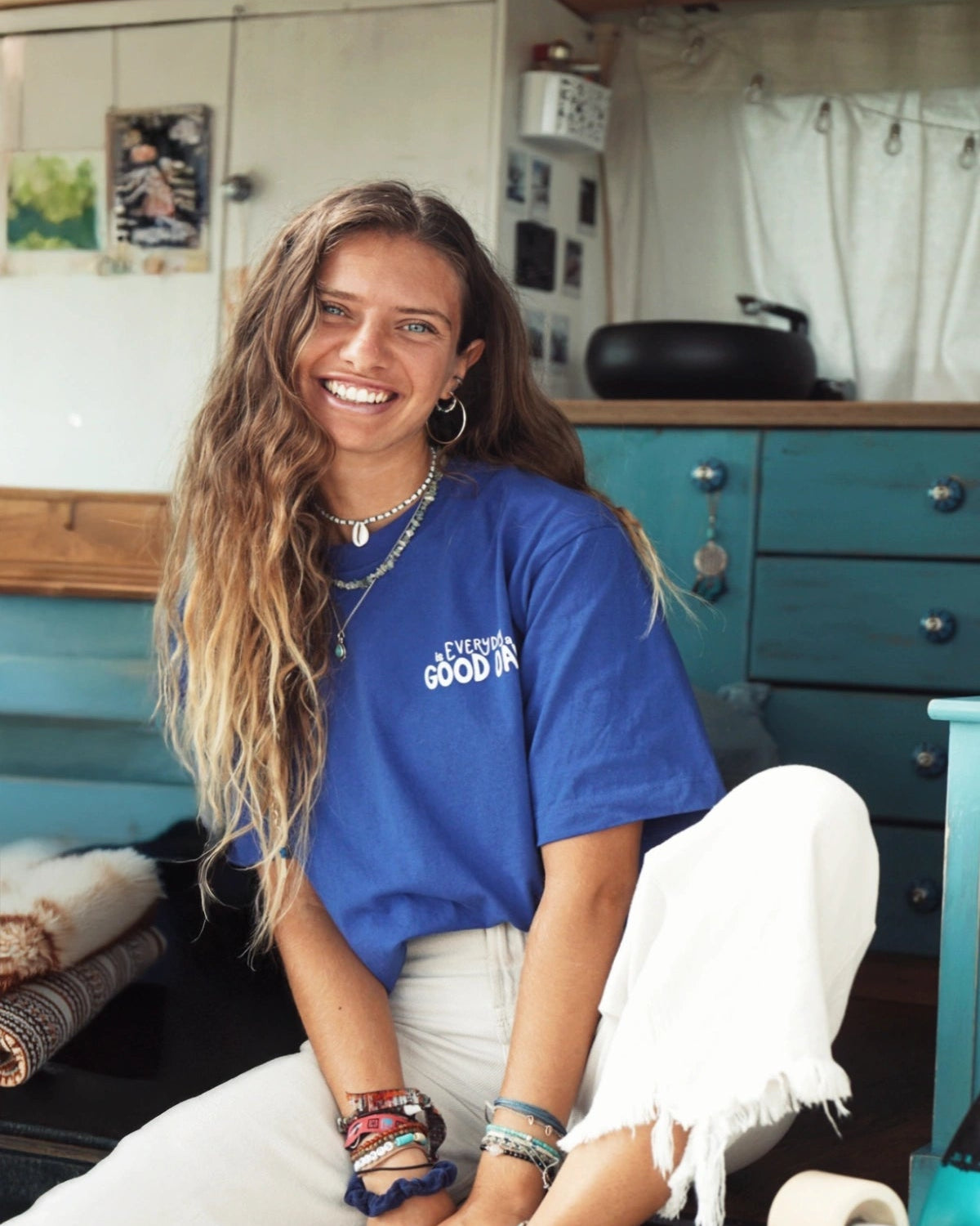 Frau im Van mit blauem Every Day Good Day Oversized T-Shirt – Frontansicht mit Lächeln