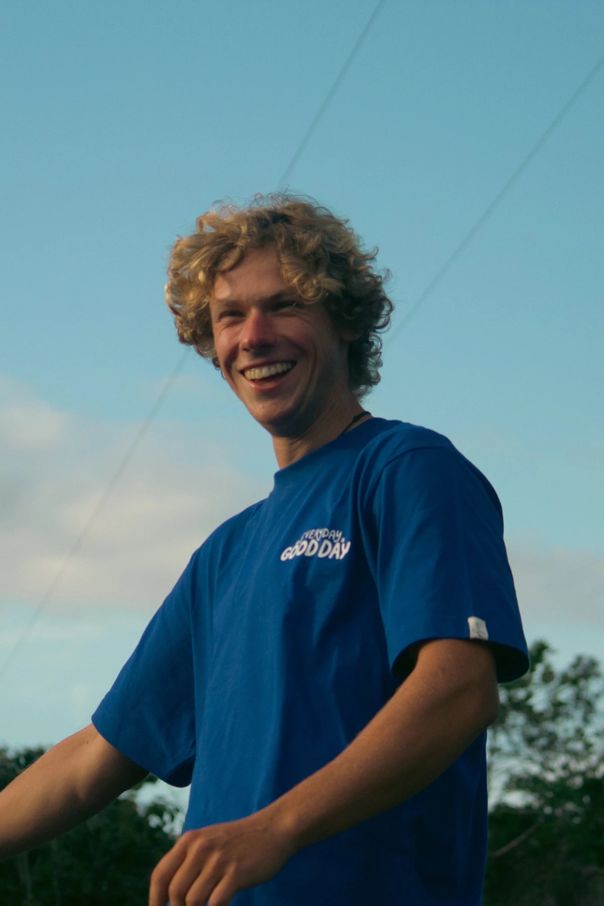 Close-up eines lächelnden Mannes im blauen Every Day Good Day T-Shirt