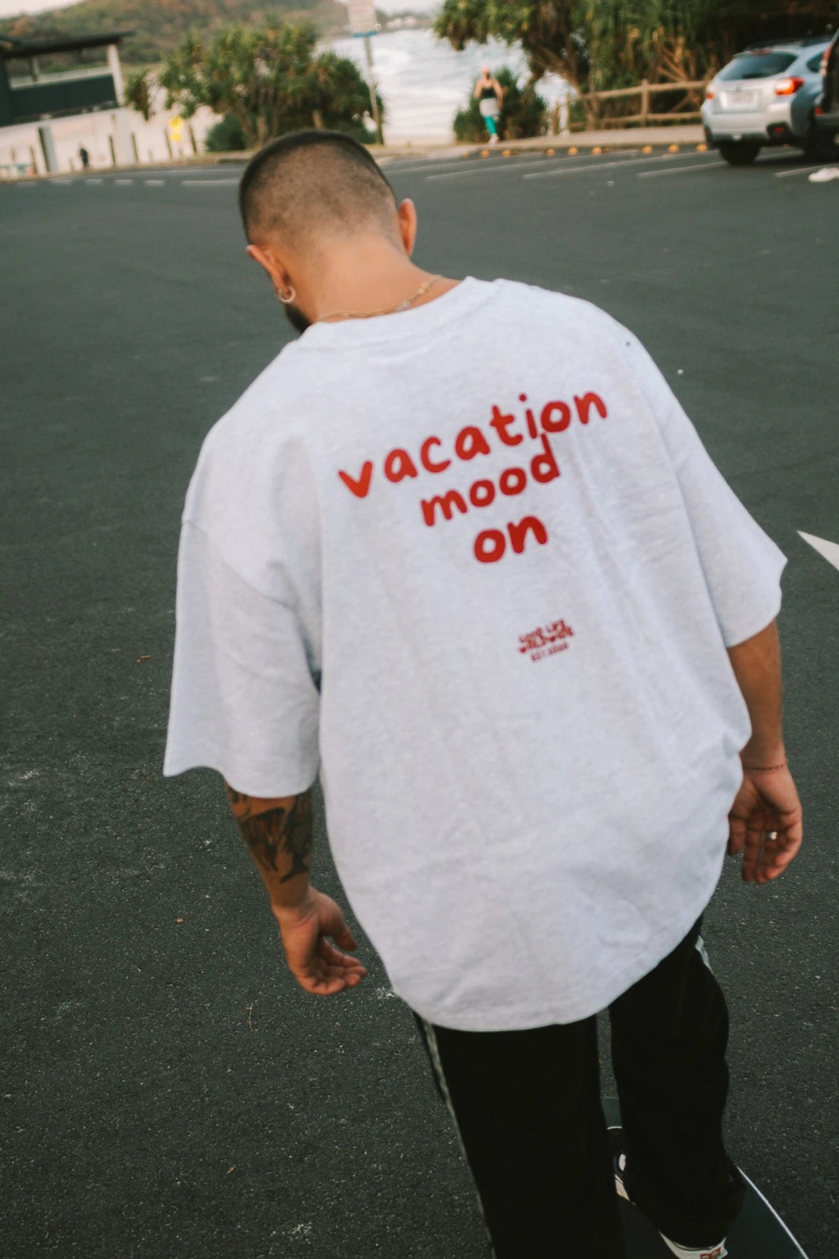 Rückansicht – Goodlife Heavy T-Shirt Cool Grey mit rotem Print „Vacation Mood On“ von The Sunkissed Rebels.
