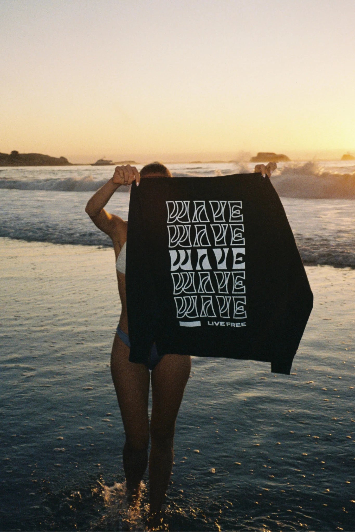 Live Free Vintage Sweater Black wird am Strand präsentiert – fair produzierte Lifestyle-Streetwear