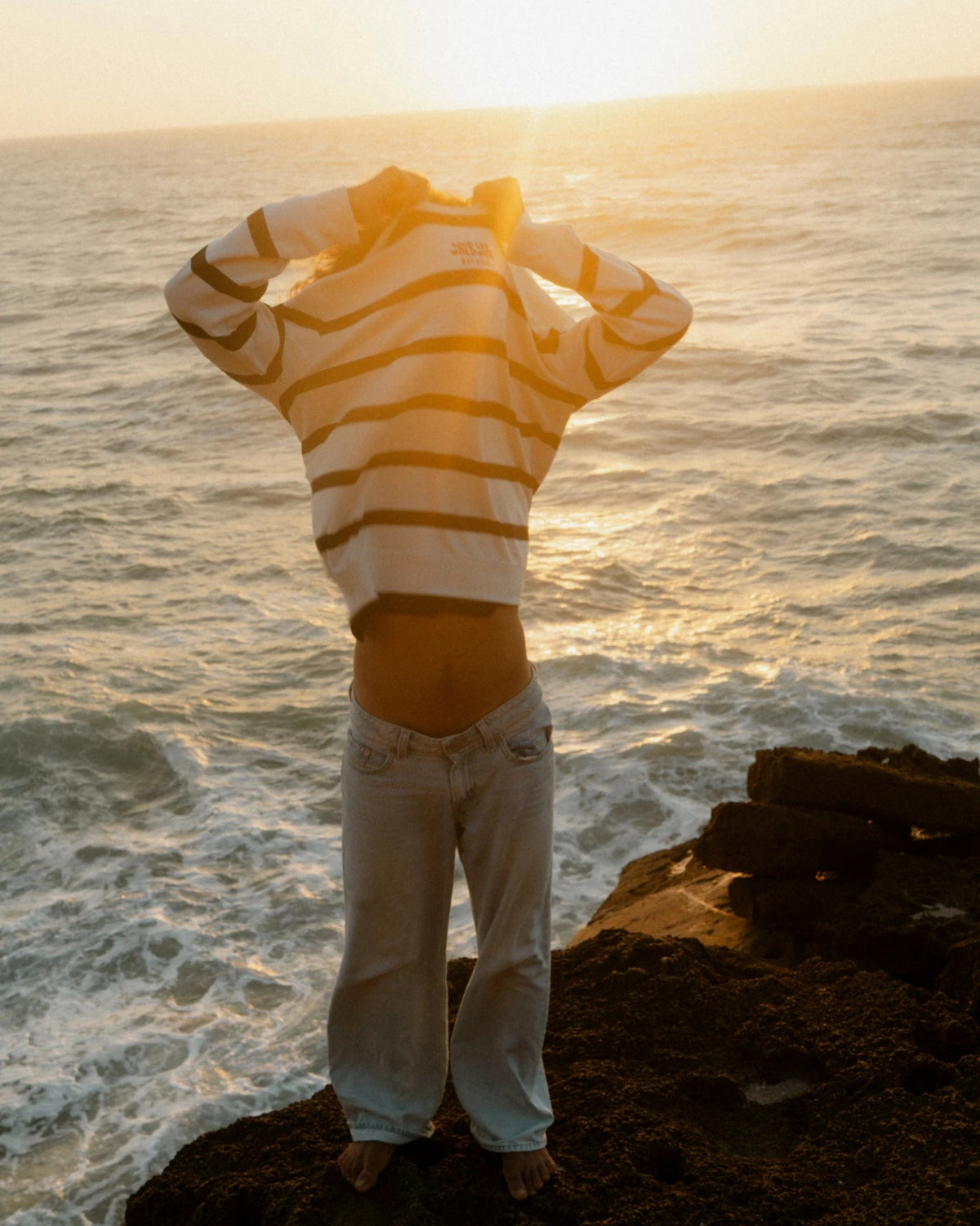 Dockside Rebel Sweater Vintage Cream bei Sonnenuntergang am Meer Lifestyle Bild