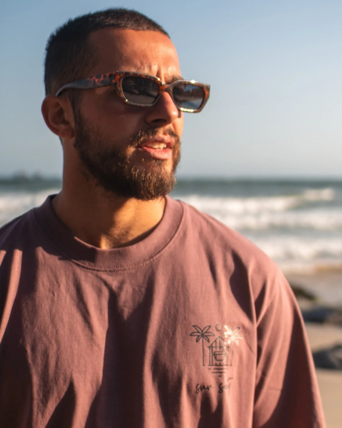 Detailansicht des Oversized T-Shirt Açaí Sun Society mit Sun Society Print am Strand