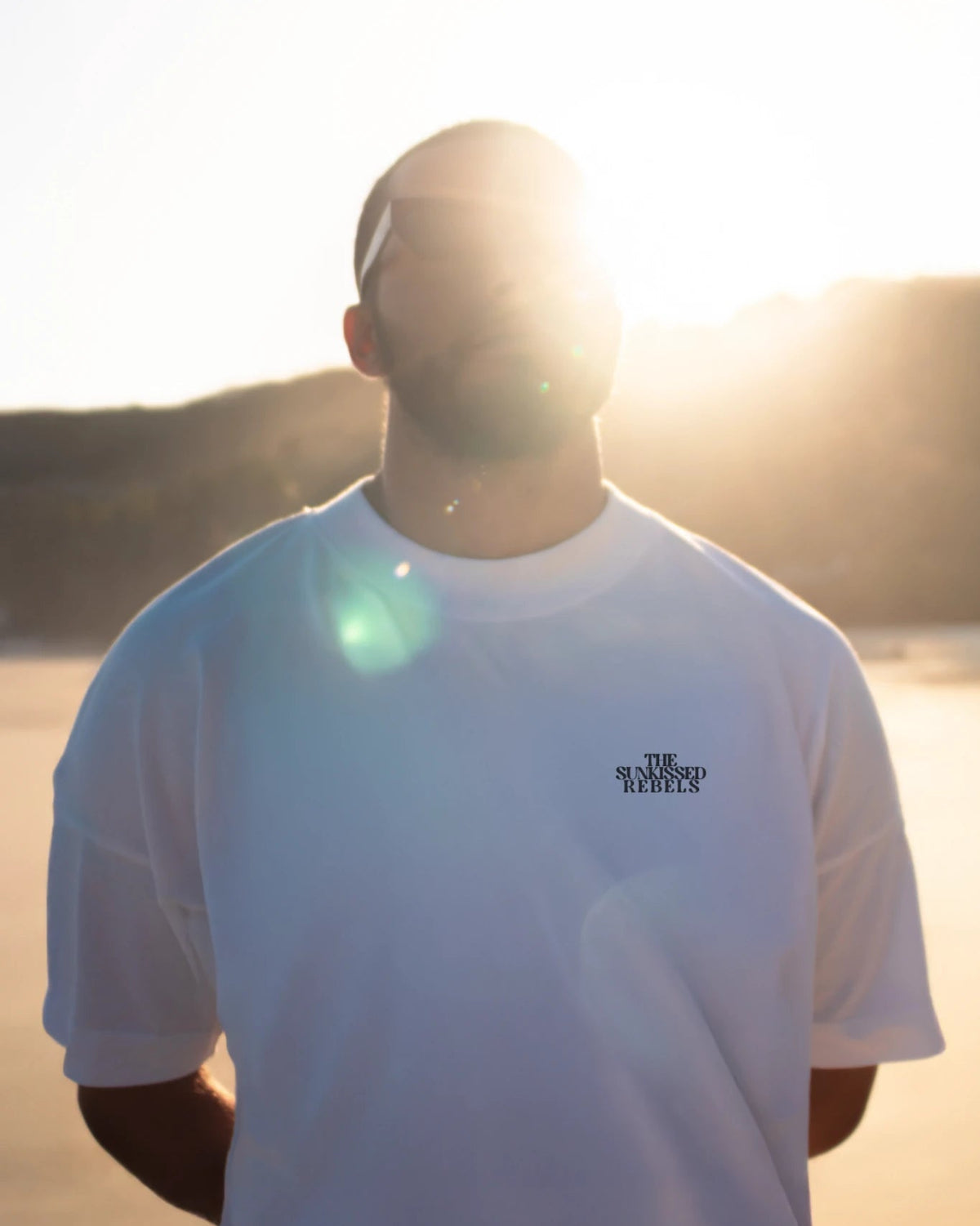 Frontansicht des Oversized T-Shirt Vacation Mood On White von The Sunkissed Rebels bei Sonnenuntergang am Strand