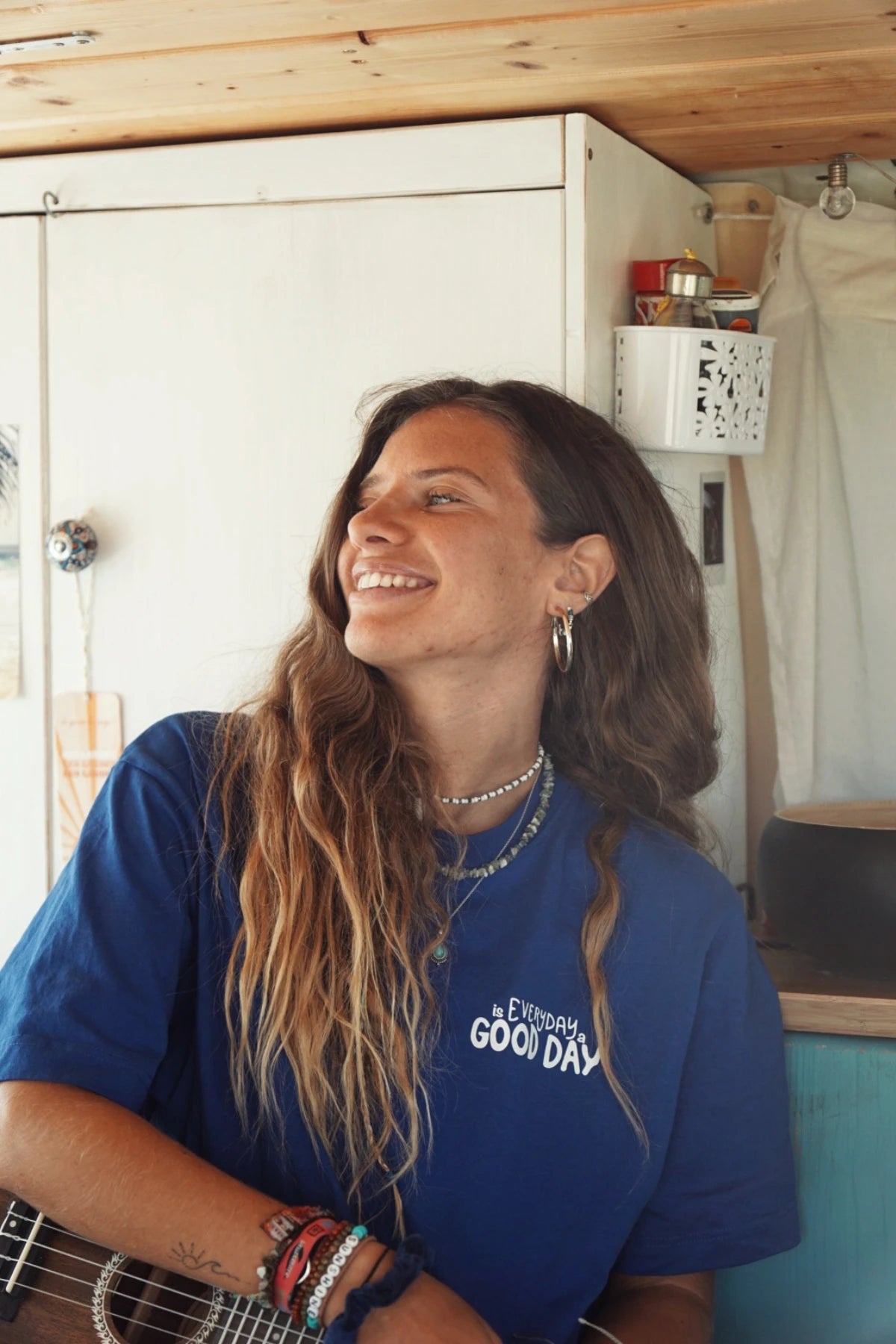 Frau mit langem Haar lacht in einem blauen Oversized T-Shirt mit "Everyday is a Good Day"