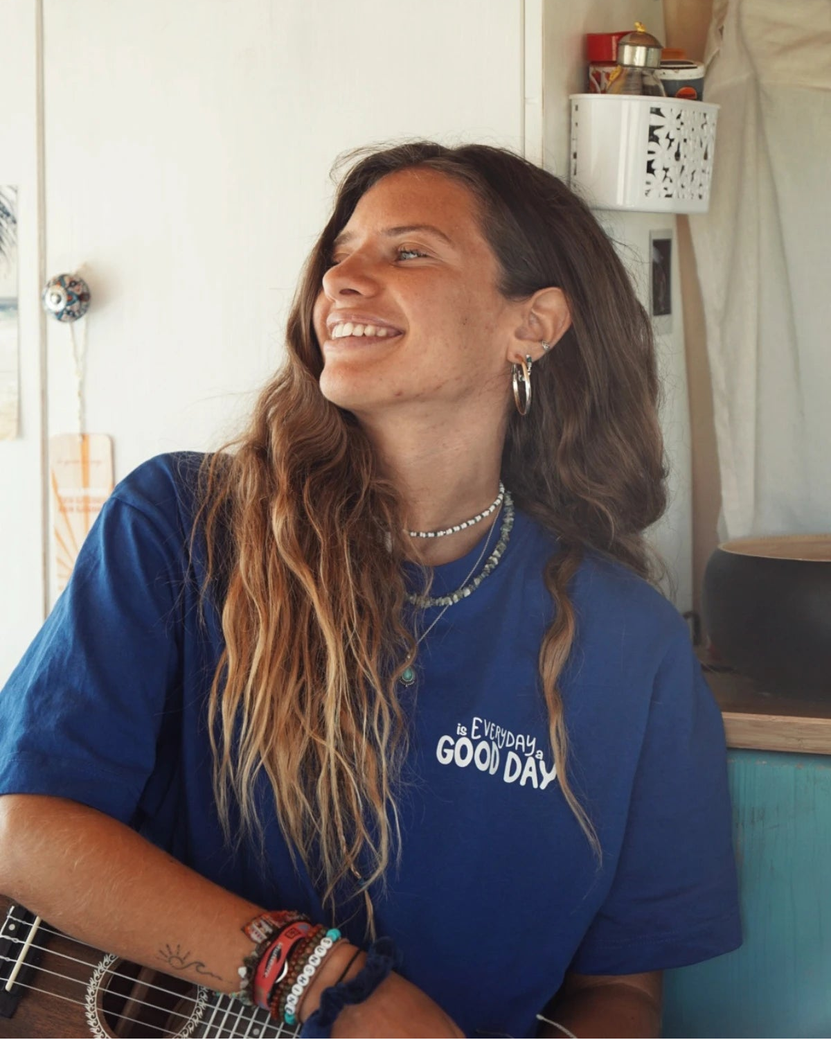Frau mit langem Haar lacht in einem blauen Oversized T-Shirt mit "Everyday is a Good Day"