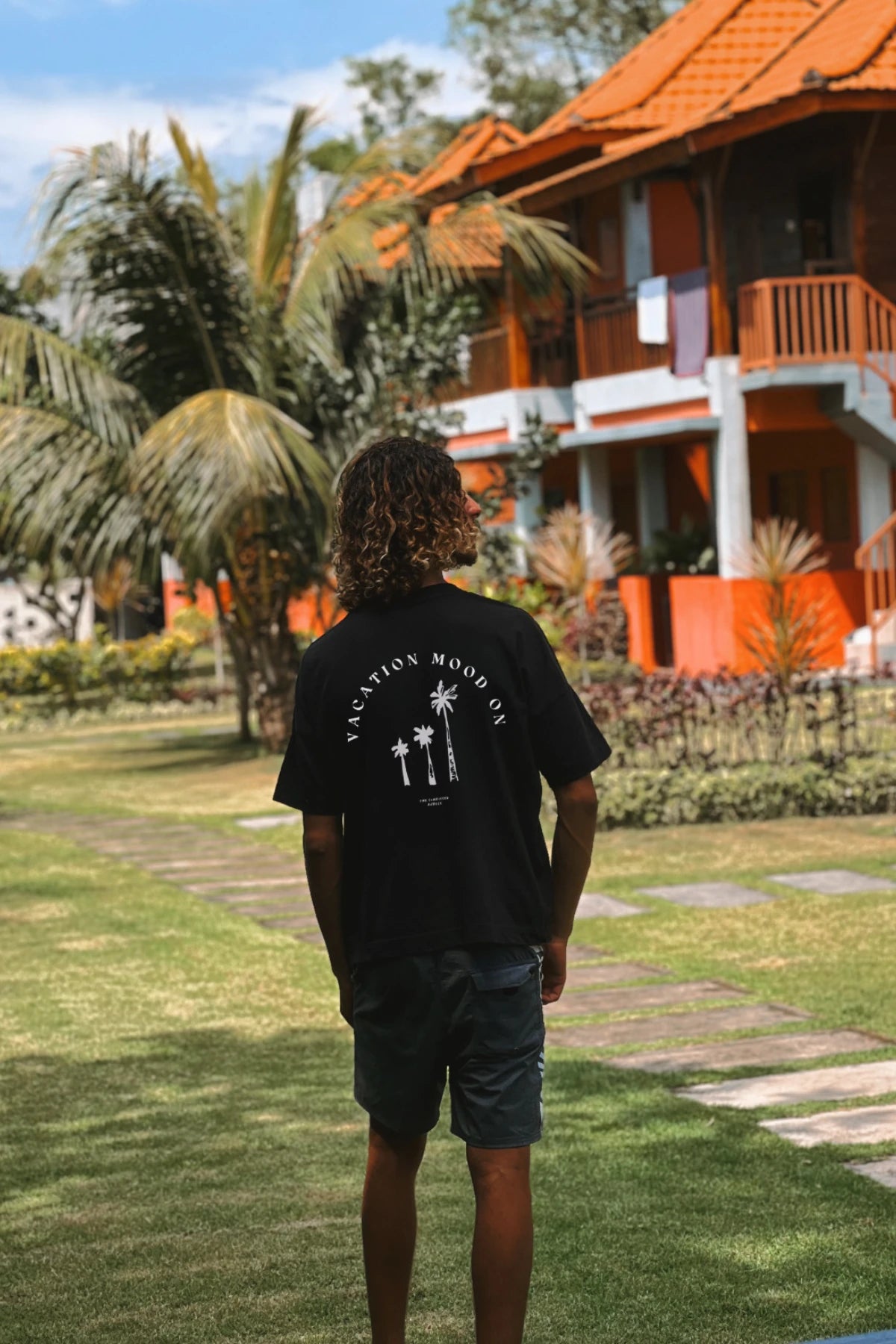 Vacation Mood On Shirt in Schwarz – Mann vor tropischem Bungalow