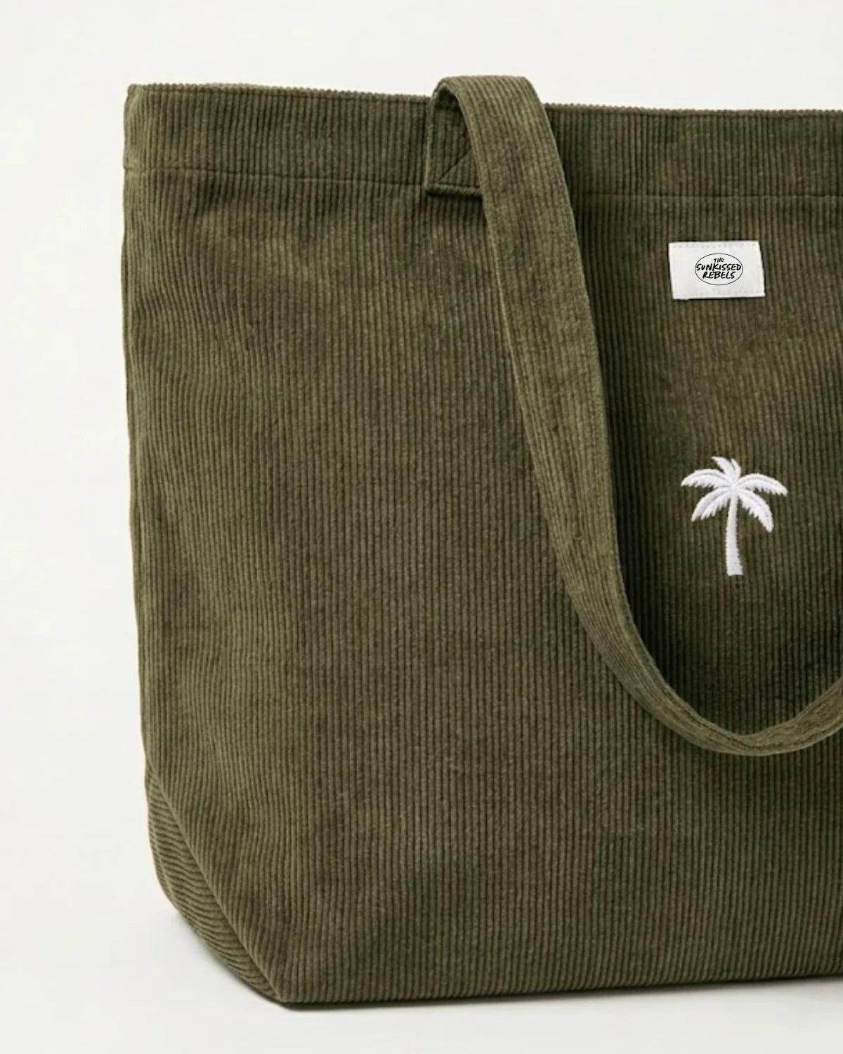 Nahaufnahme der olivgrünen Palm Tree Cord Bag aus Feincord mit weiß gestickter Palme und The Sunkissed Rebels Marken-Patch.