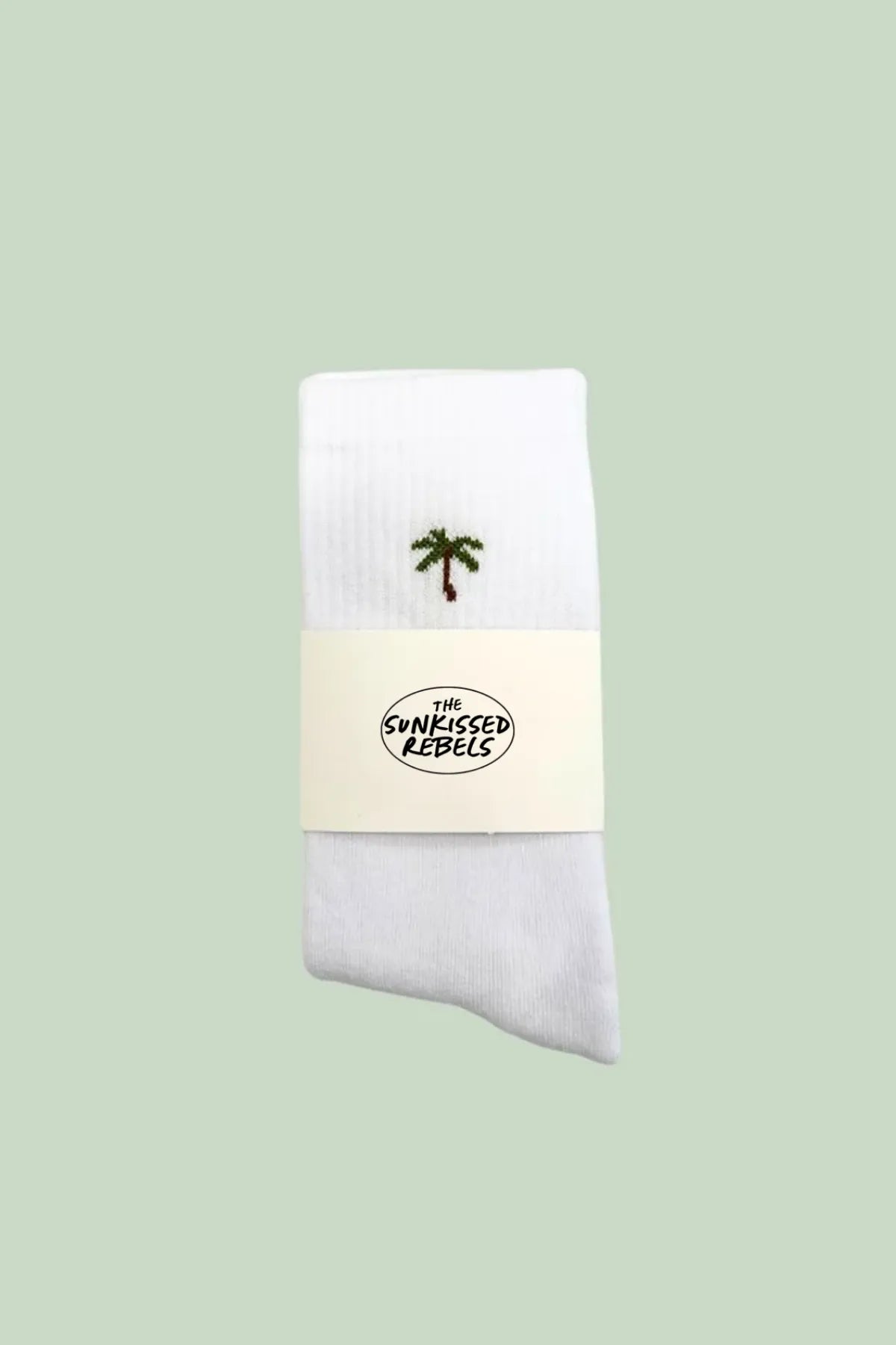 Weiße Tennissocken mit kleiner Palmenstickerei, verpackt mit The Sunkissed Rebels Branding.