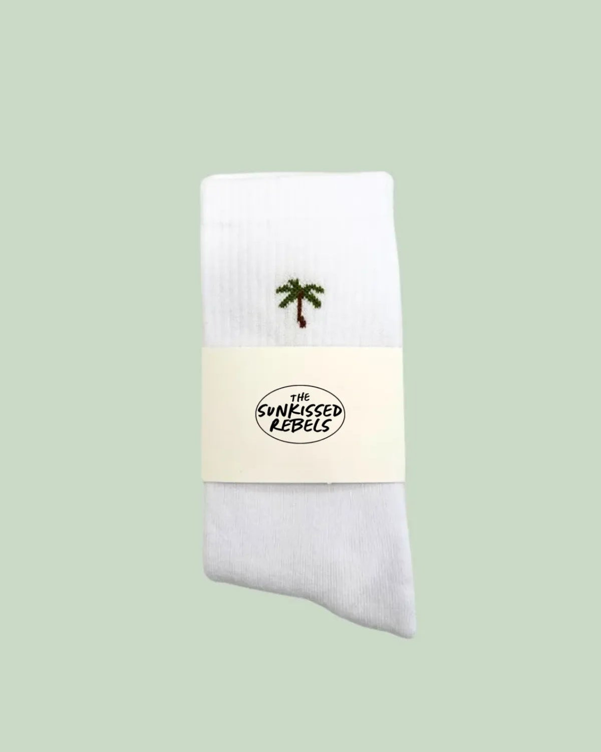 Weiße Tennissocken mit kleiner Palmenstickerei, verpackt mit The Sunkissed Rebels Branding.