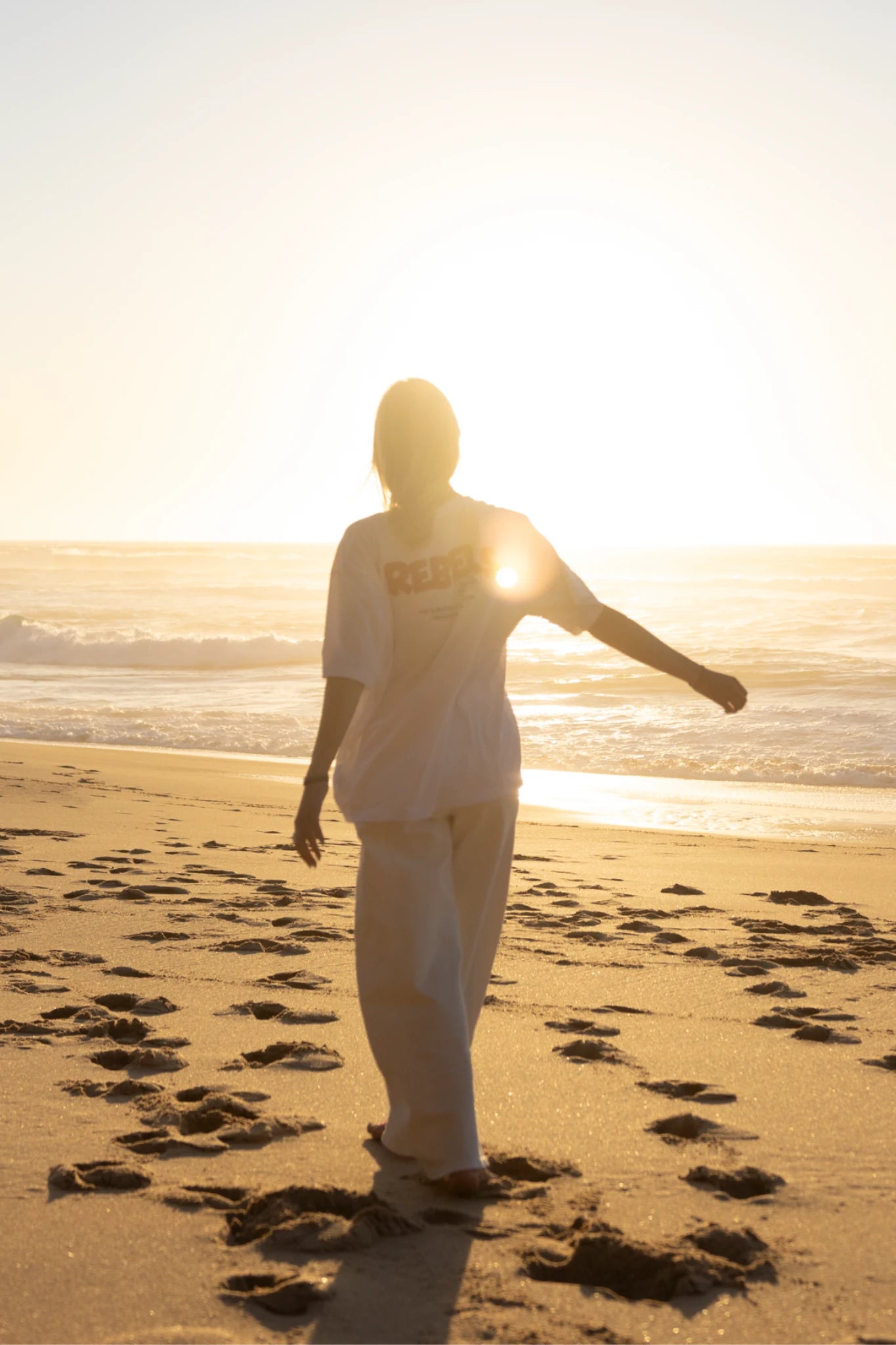 Rebels Surf Wear Light T-Shirt White Rückenansicht im Sonnenuntergang am Strand