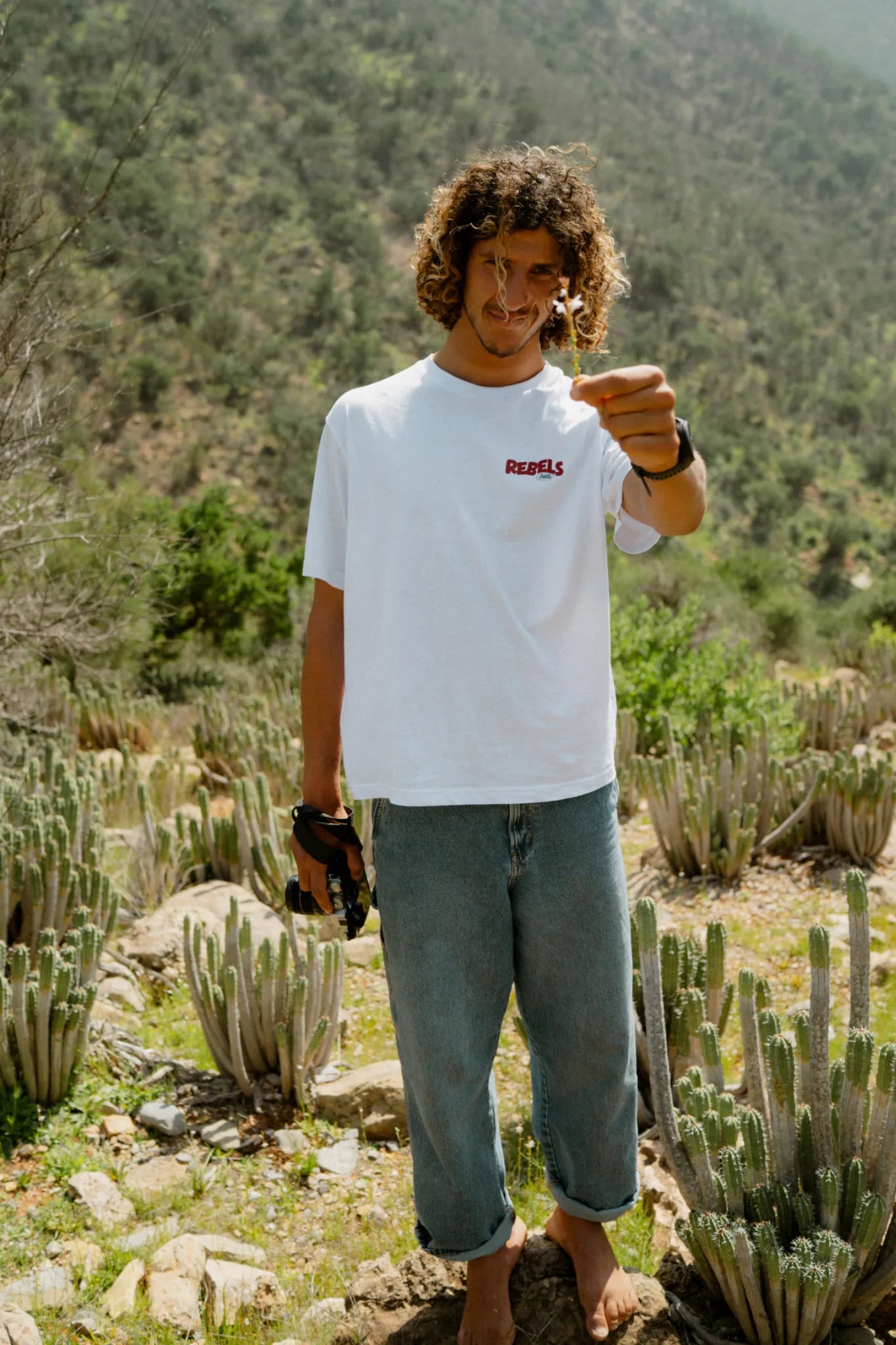 Rebels Surf Wear oversized t-shirt white model holding flower cactus background