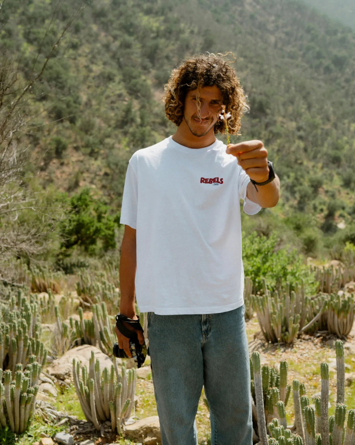 Rebels Surf Wear oversized t-shirt white model holding flower cactus background