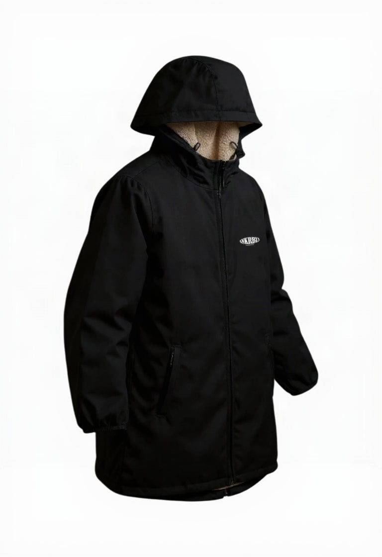 Schwarze wasserdichte Sherpa-Jacke von Rebels mit Kapuze, weichem Teddyfutter und seitlichen Reißverschlusstaschen, seitliche schräge Produktansicht.