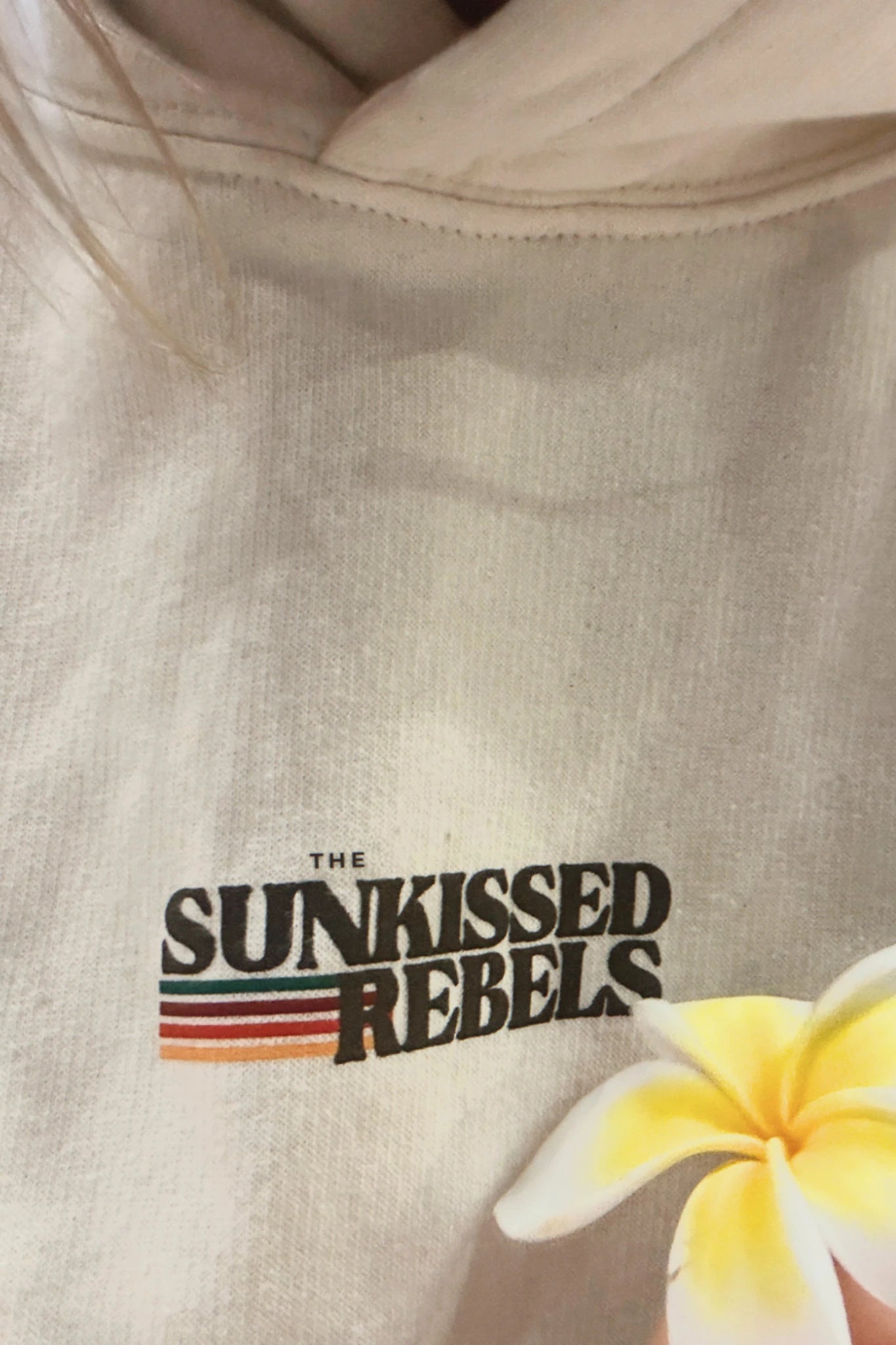 Detailaufnahme vom Sunkissed Rebels Logo auf dem Retro Vibes Hoodie Cream