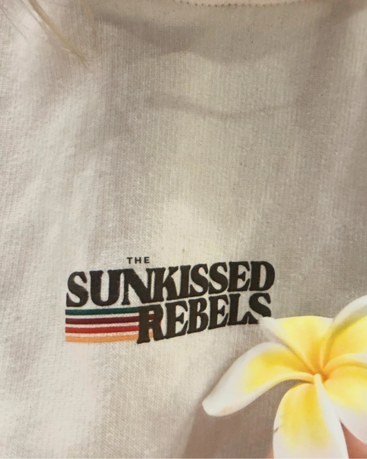 Detailaufnahme vom Sunkissed Rebels Logo auf dem Retro Vibes Hoodie Cream