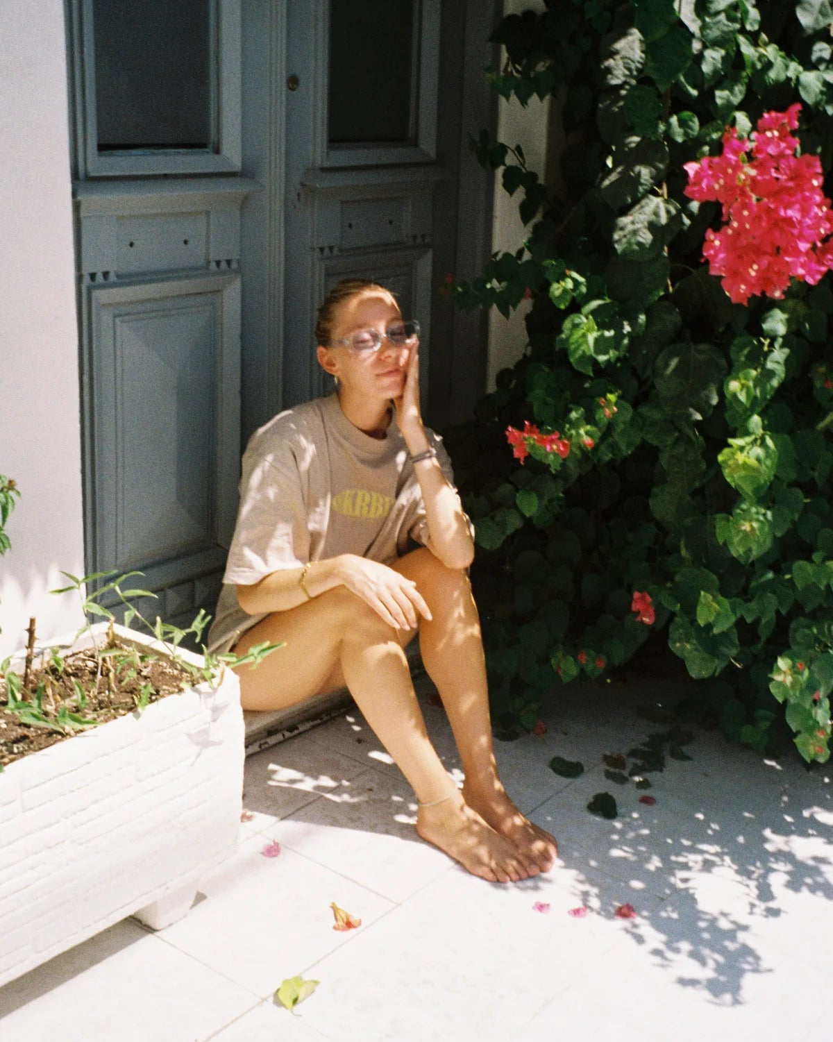 Frau sitzt entspannt im Schatten mit Oversized T-Shirt – lässiger Sommermoment