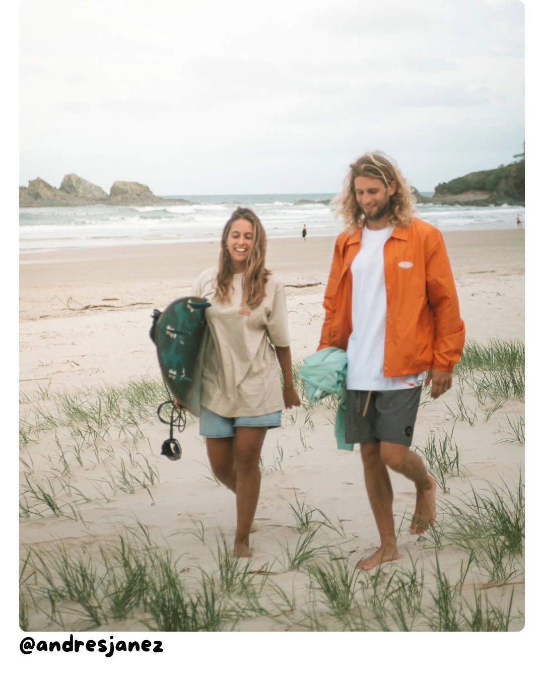 Model von The Sunkissed Rebels läuft am Strand und trägt ein lässiges Unisex Outfit aus T-Shirt und leichter Jacke.