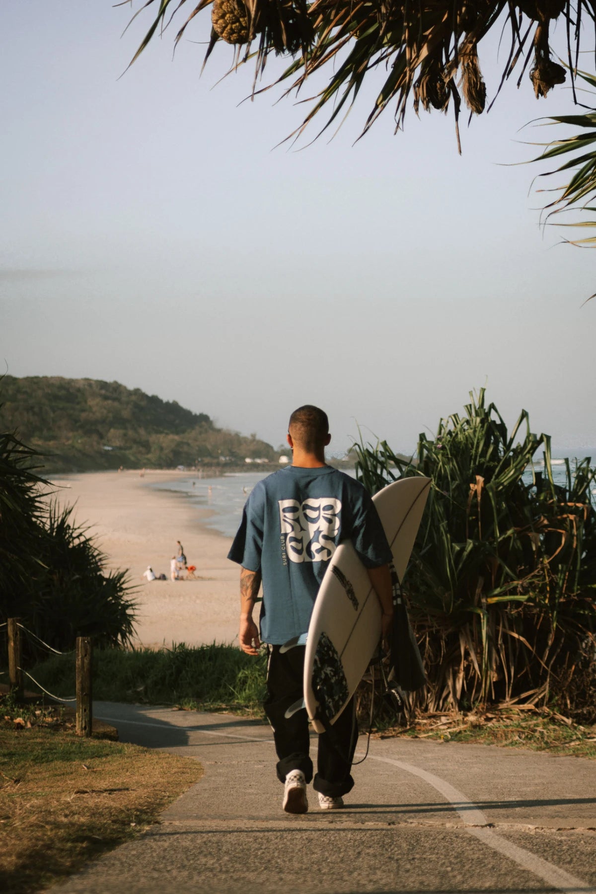Surf Club Heavy T-Shirt Deep Blue von The Sunkissed Rebels vor der Brandung – modernes Herren Surfshirt mit urbanem Touch.