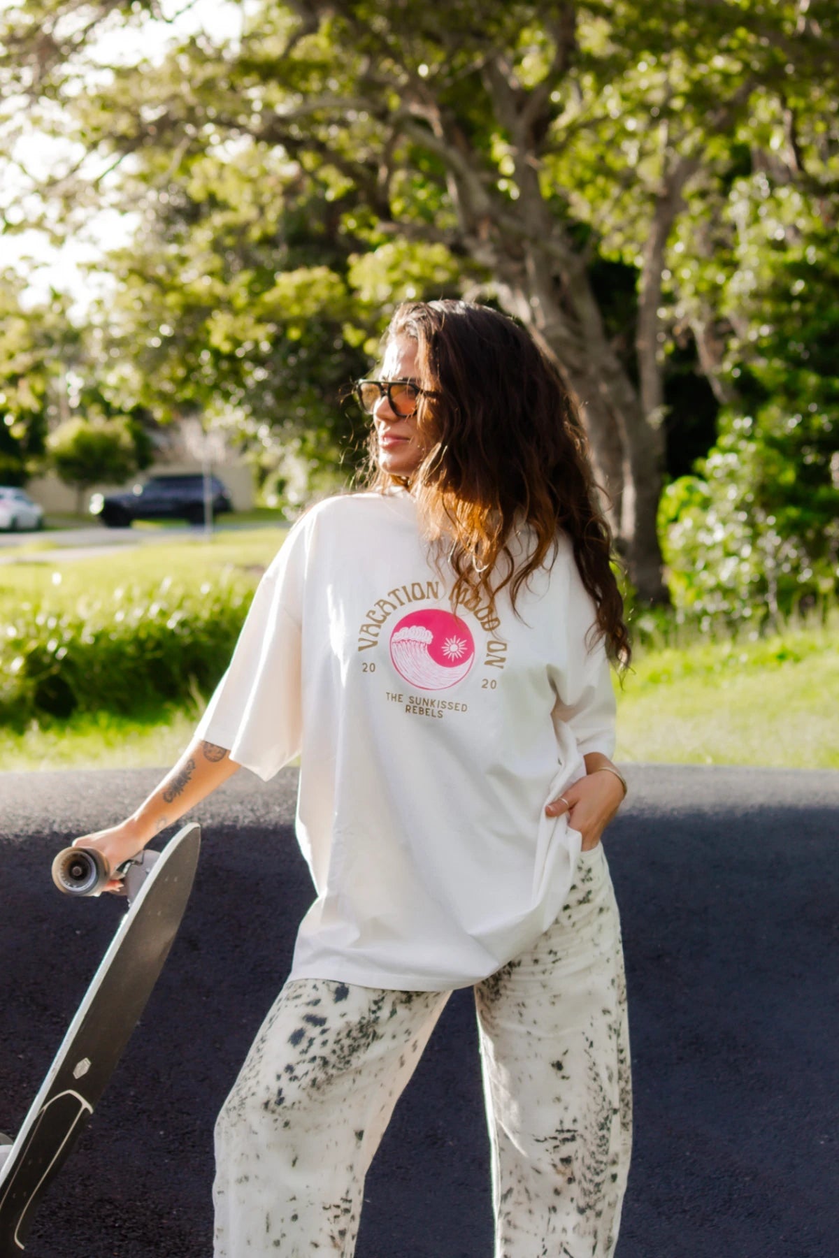 Lachende Frau mit Sonnenbrille und Skateboard im Vacation Mood On Shirt von The Sunkissed Rebels