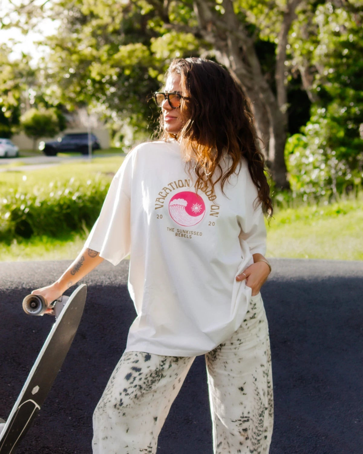 Lachende Frau mit Sonnenbrille und Skateboard im Vacation Mood On Shirt von The Sunkissed Rebels