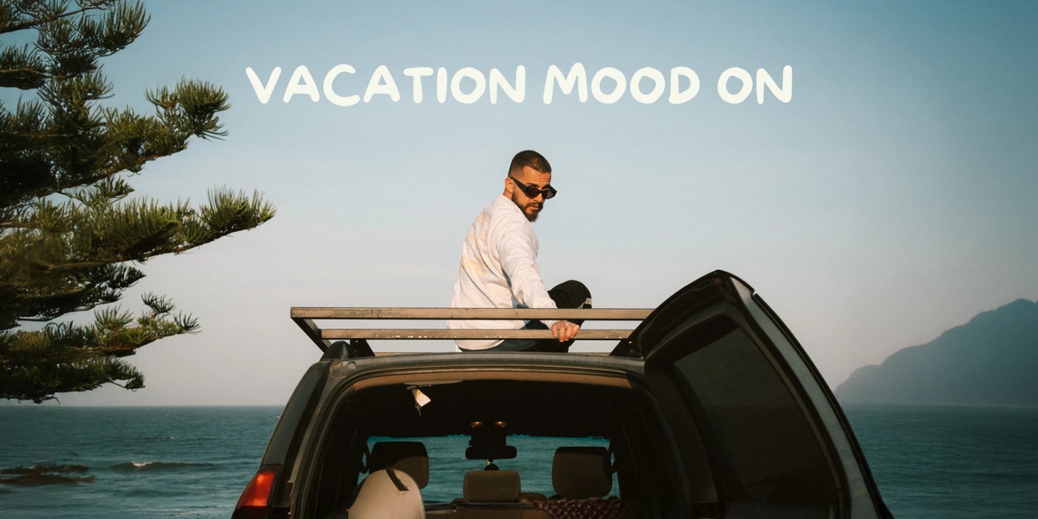 Model von The Sunkissed Rebels sitzt auf Autodach am Strand