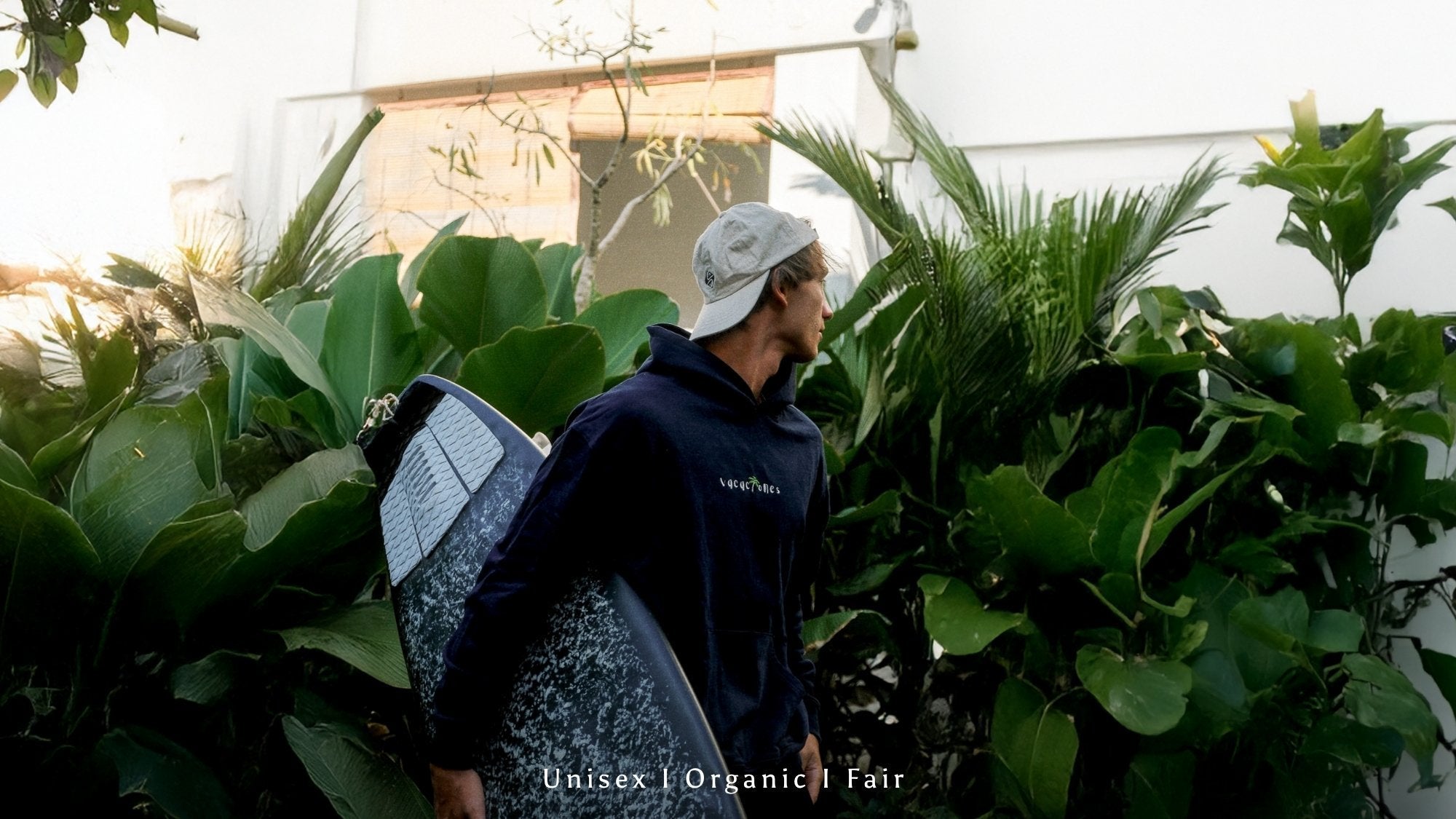 Mann sitzt auf Bank an Küste in greuame Sweater vonm The Sunkissed Rebels