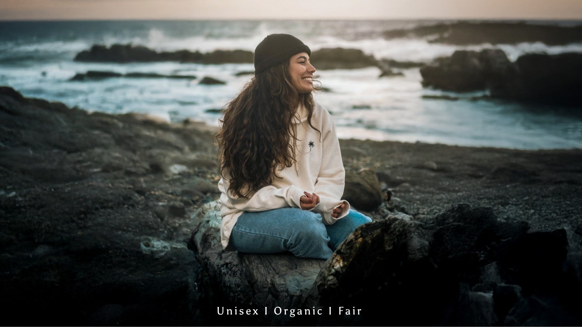 Paar steht am Strand mit gelben Hoodie und schwarzem Sweater von The Sunkissed Rebels