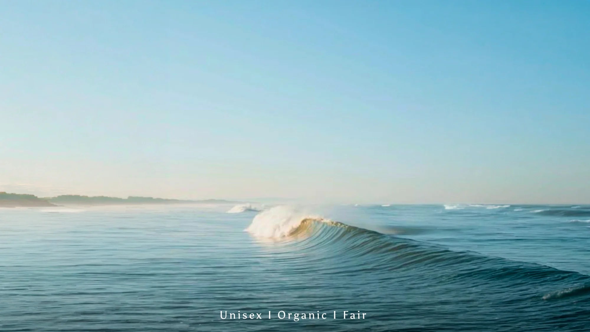 Sanfte Ozeanwelle bei Sonnenaufgang mit minimalistischer Unisex Organic Fair Fashion Ästhetik und ruhiger Surf Lifestyle Stimmung.