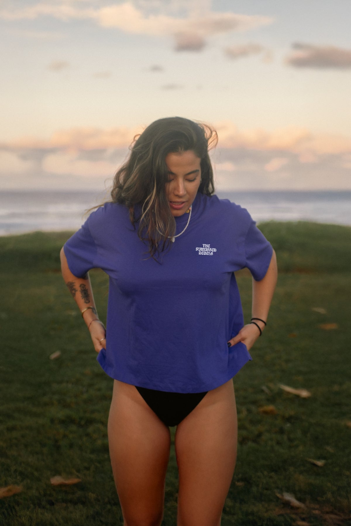 Frau am Strand trägt lila Crop T-Shirt mit druck 