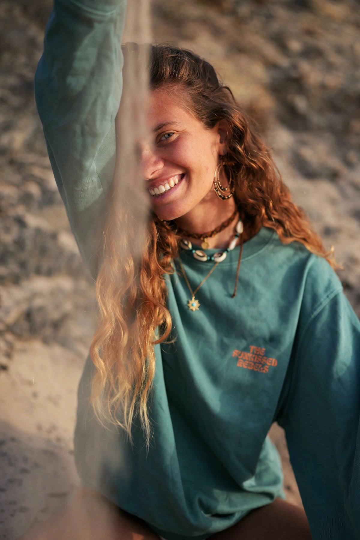 Frau mit Muschelkette lächelt in Palm Green Live Free Sweater