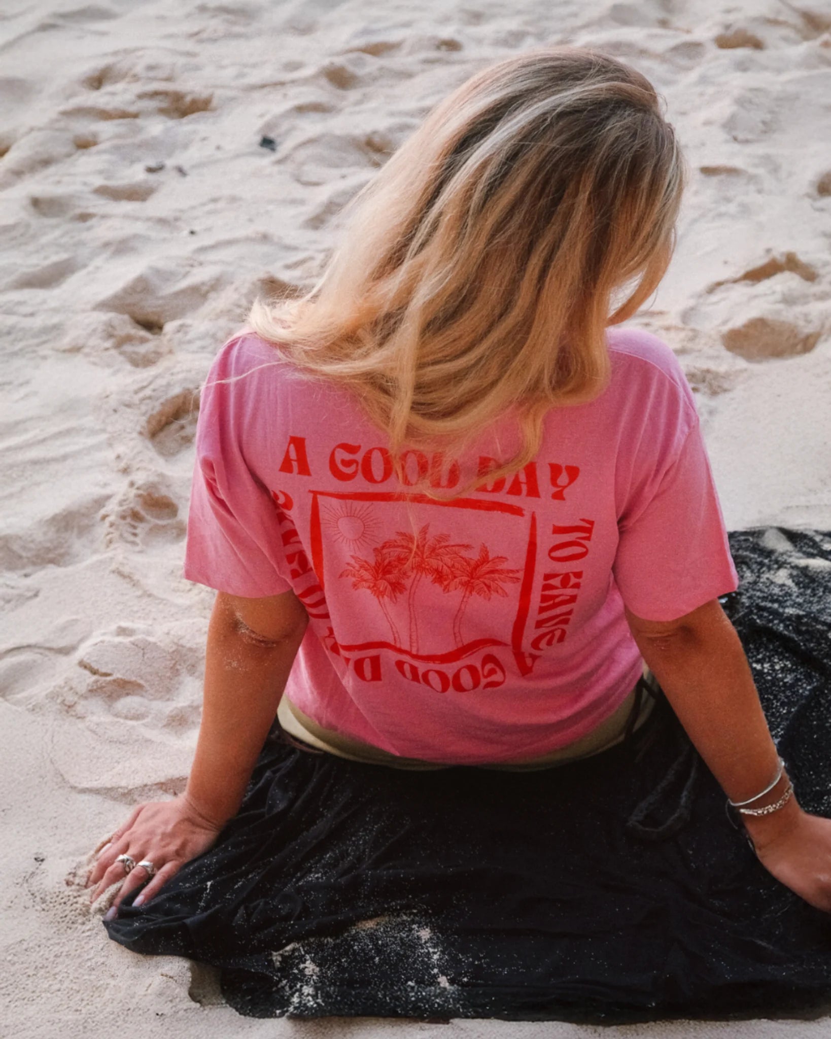 The Sunkissed Rebels Pink Summer Backprint Shirt – Damen T-Shirt mit rotem Print am Strand fotografiert