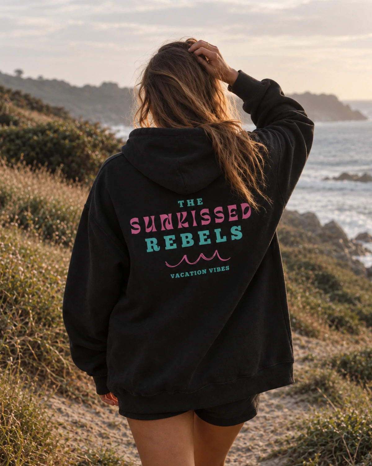 Rückansicht des schwarzen Vacation Vibes Oversized Hoodies mit großem The Sunkissed Rebels Vacation Vibes Rückenprint