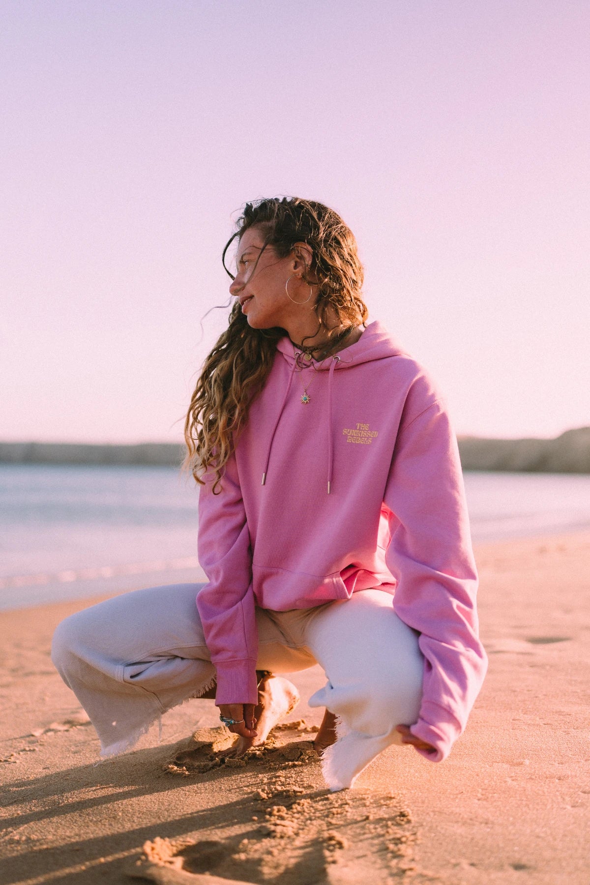 Detailaufnahme des A Good Day Hoodies in Bubble Pink mit natürlichem Sonnenlicht am Strand.