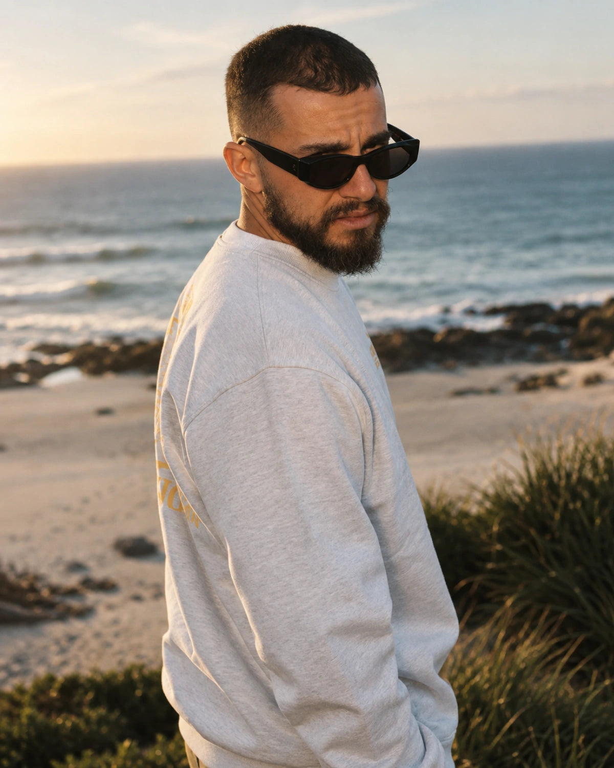 A Good Day Oversized Sweater Cool Grey – seitliche Herrenansicht an der Küste