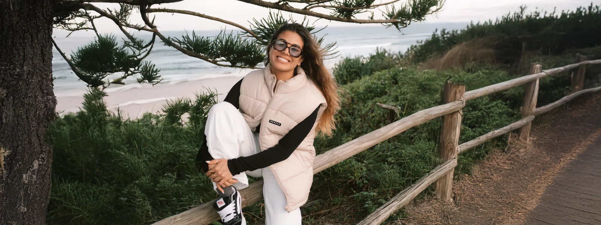 Frau trägt beige Puffer Weste am meer