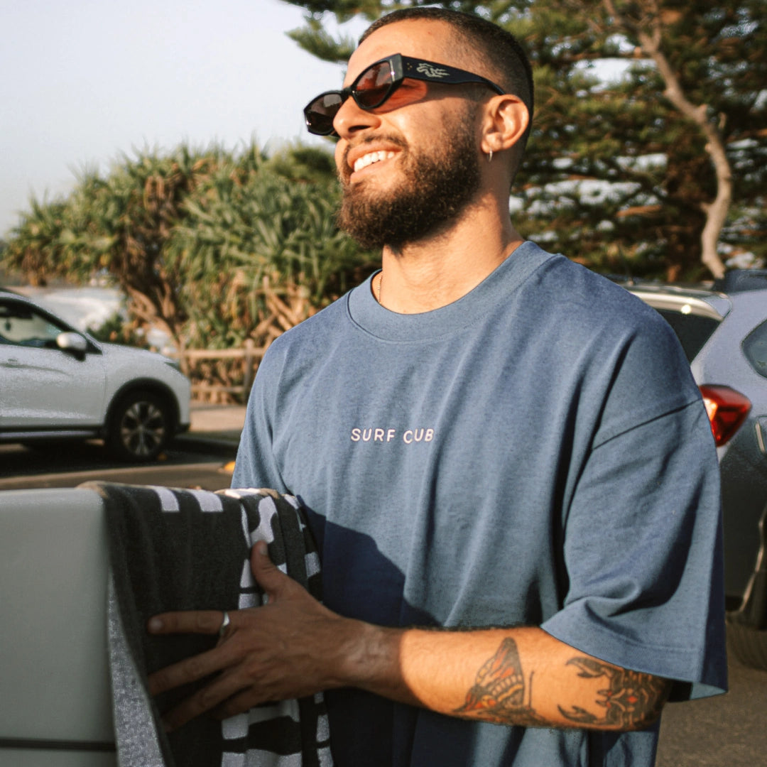 Mann läcvhelt und trägt blaues Oversized T-shirt  Strteetstyle